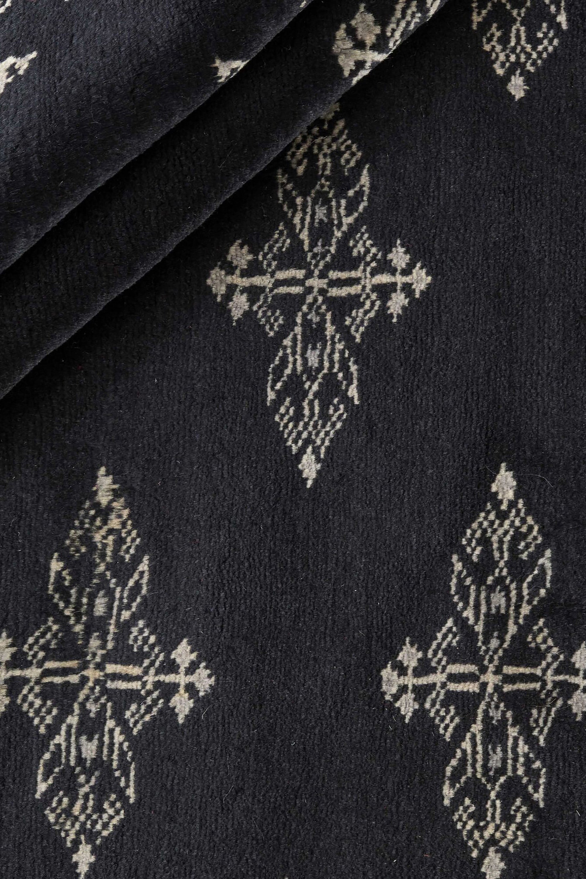 Black Oriental rug with traditional bordered pattern