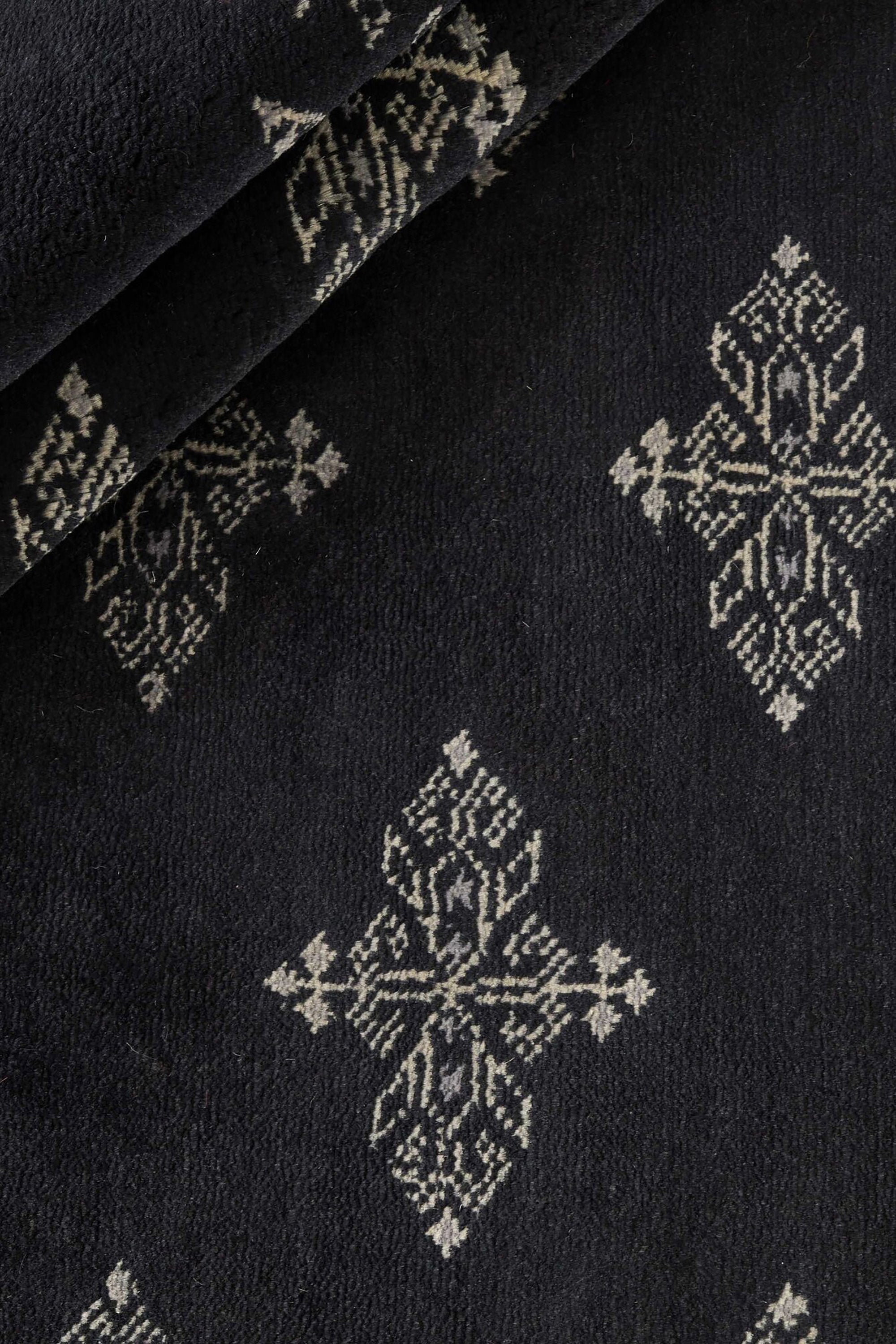 Black Oriental rug with traditional bordered pattern