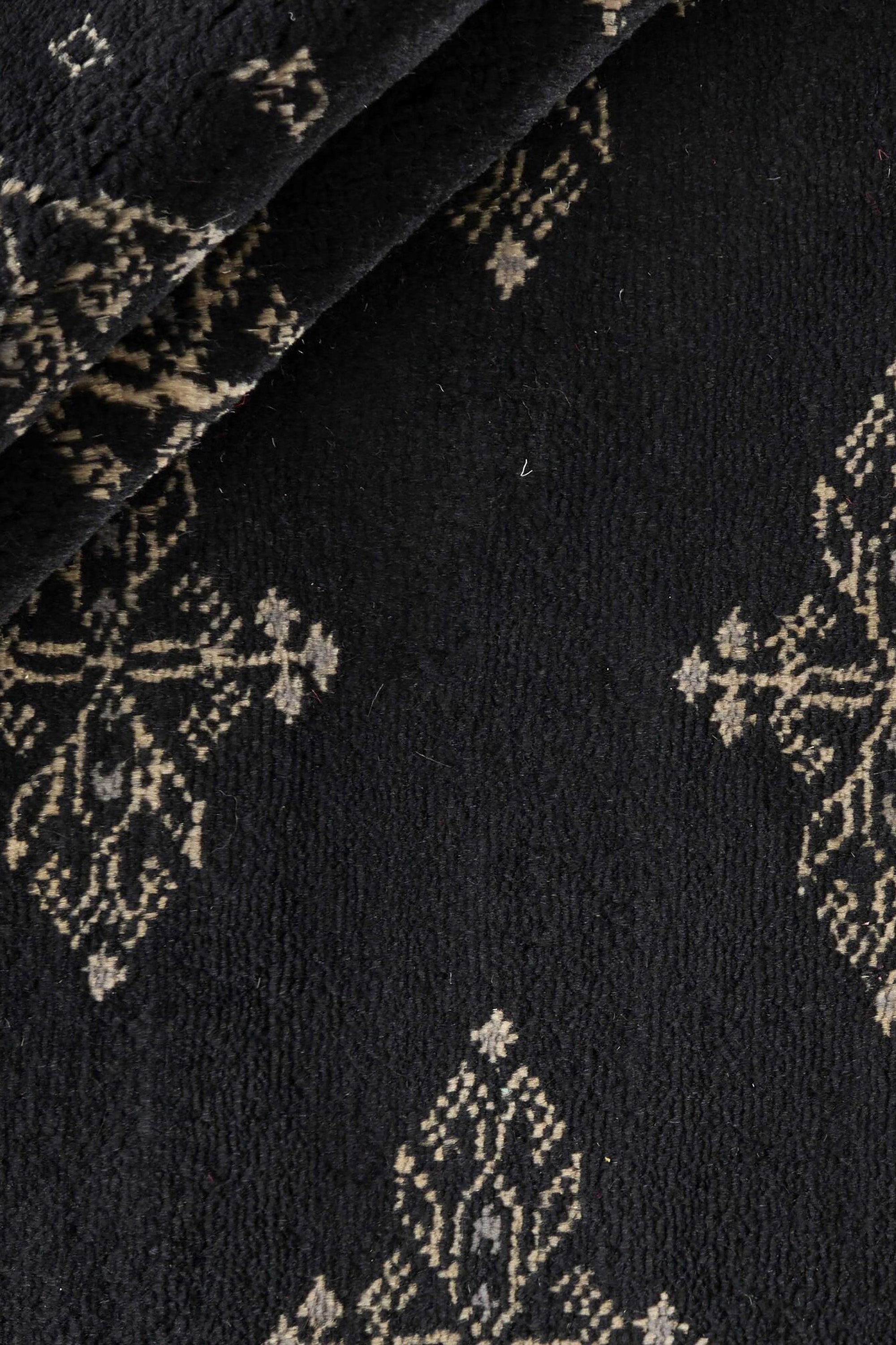 Black Oriental rug with traditional bordered pattern