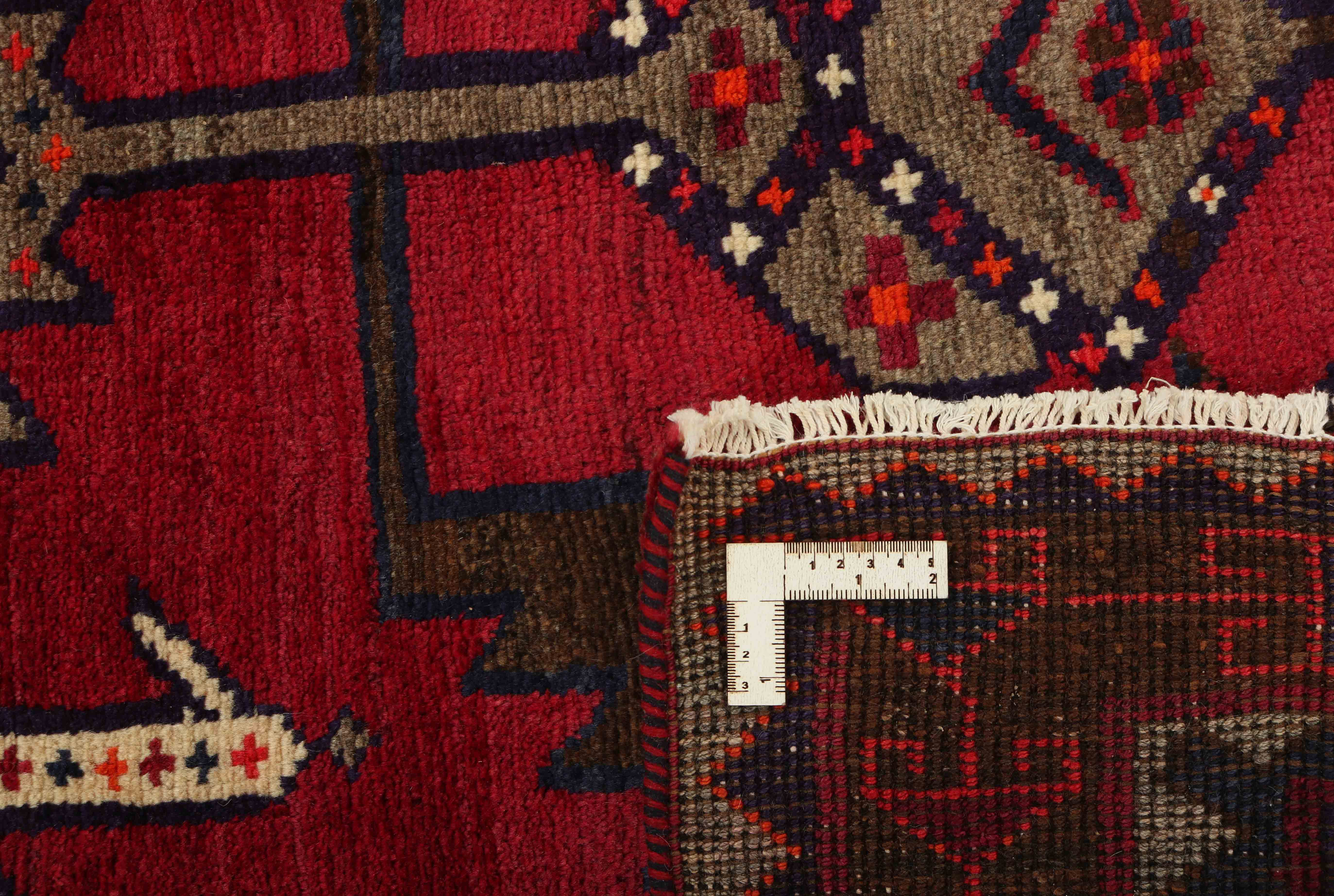 Red and white persian rug with traditional tribal geometric pattern