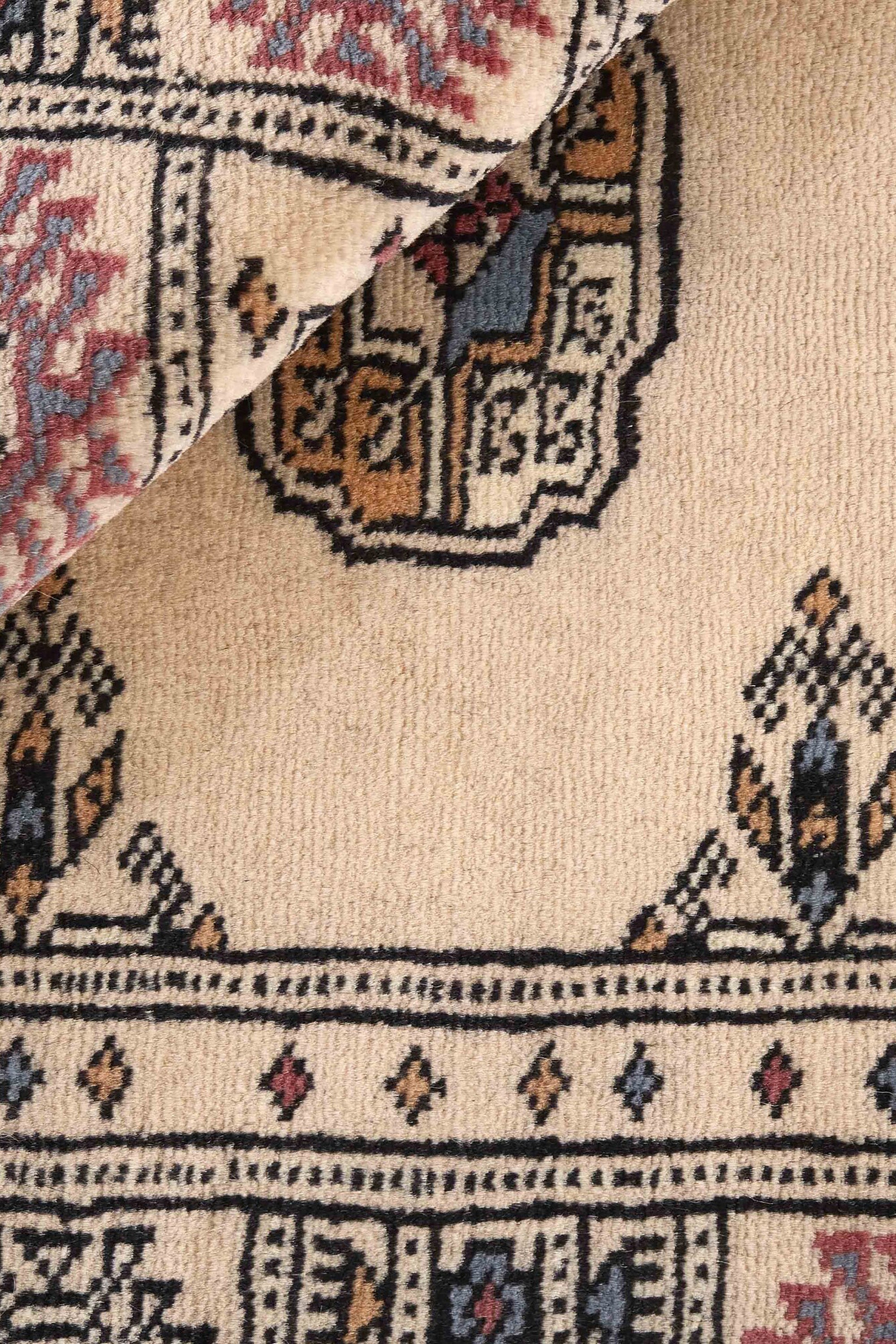 Beige Oriental rug with traditional bordered pattern