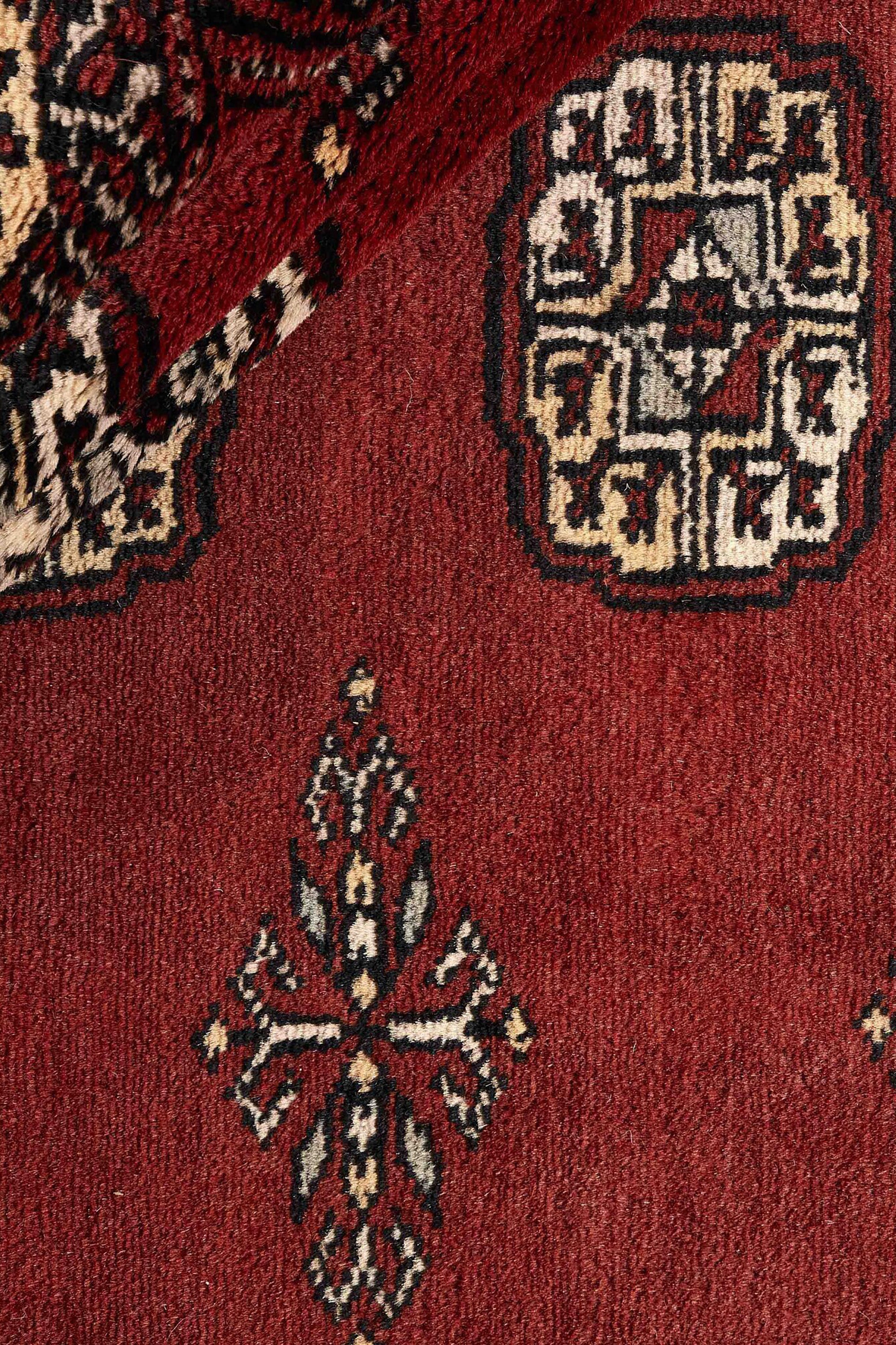 Red Oriental rug with traditional bordered pattern