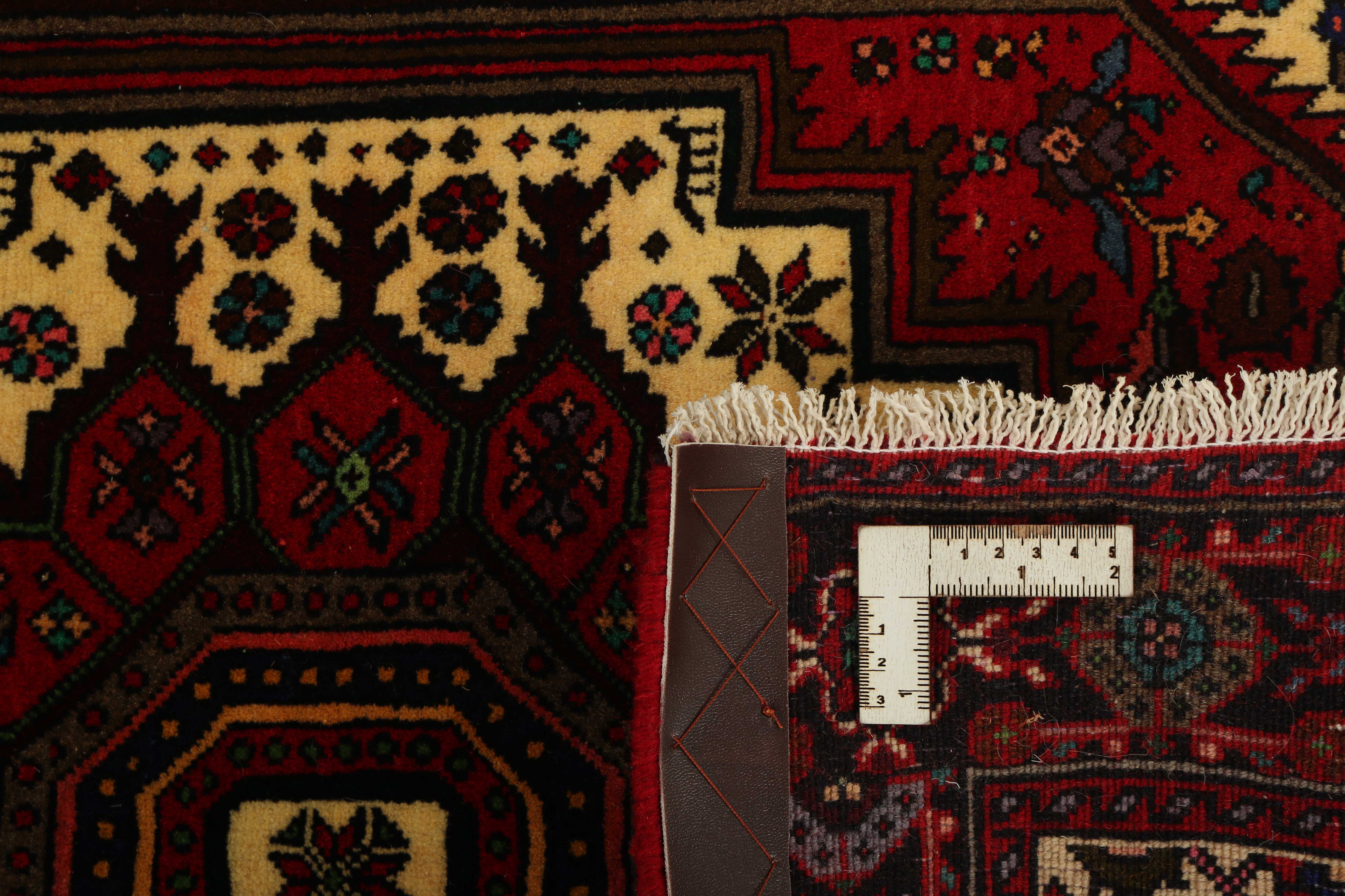 Red and beige persian rug with a floral design