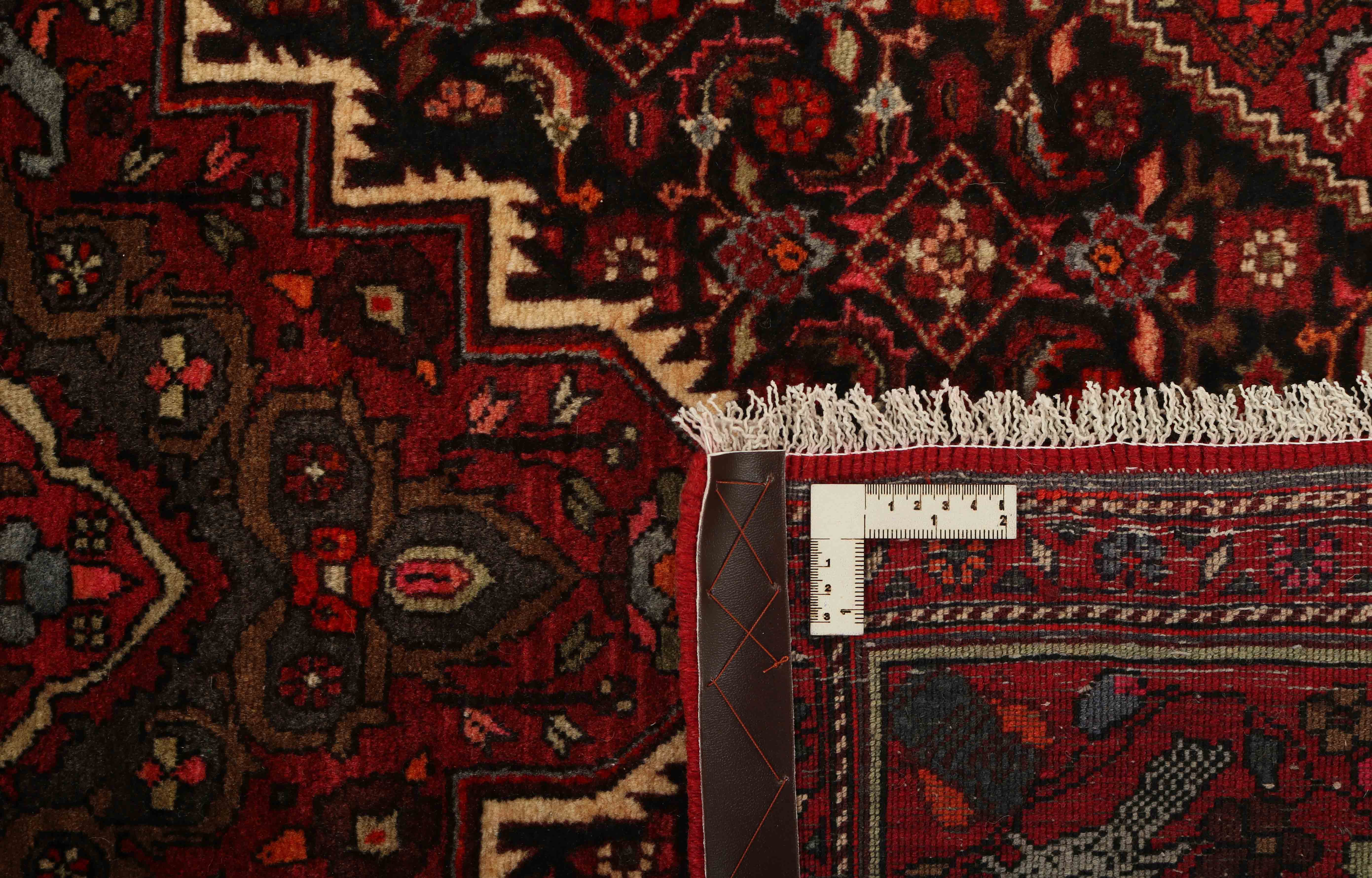 Red and beige persian rug with a floral design