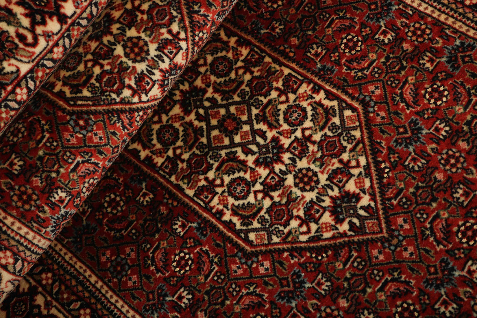 Red and cream persian wool and silk runner with traditional floral design