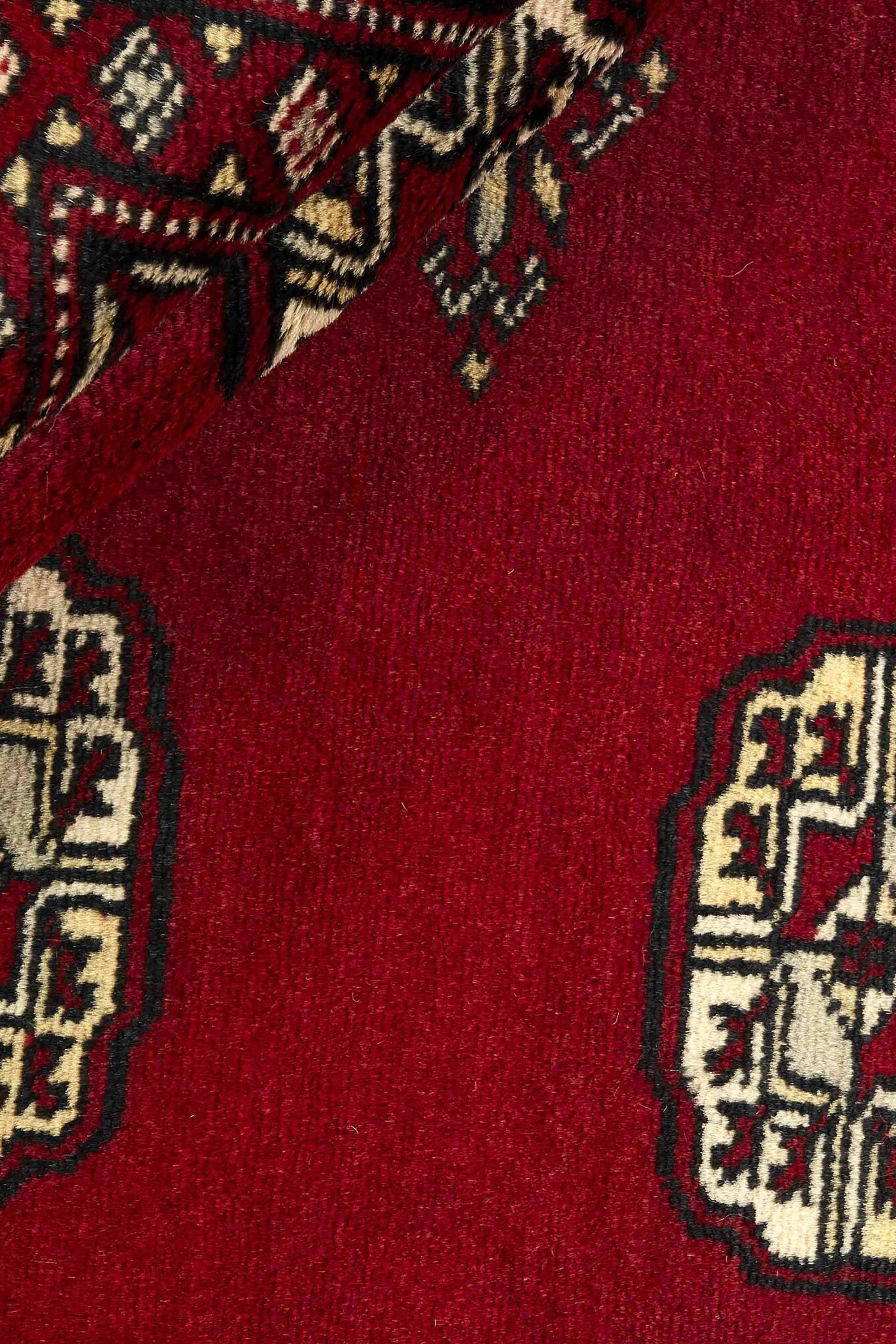 Red Oriental rug with traditional bordered pattern