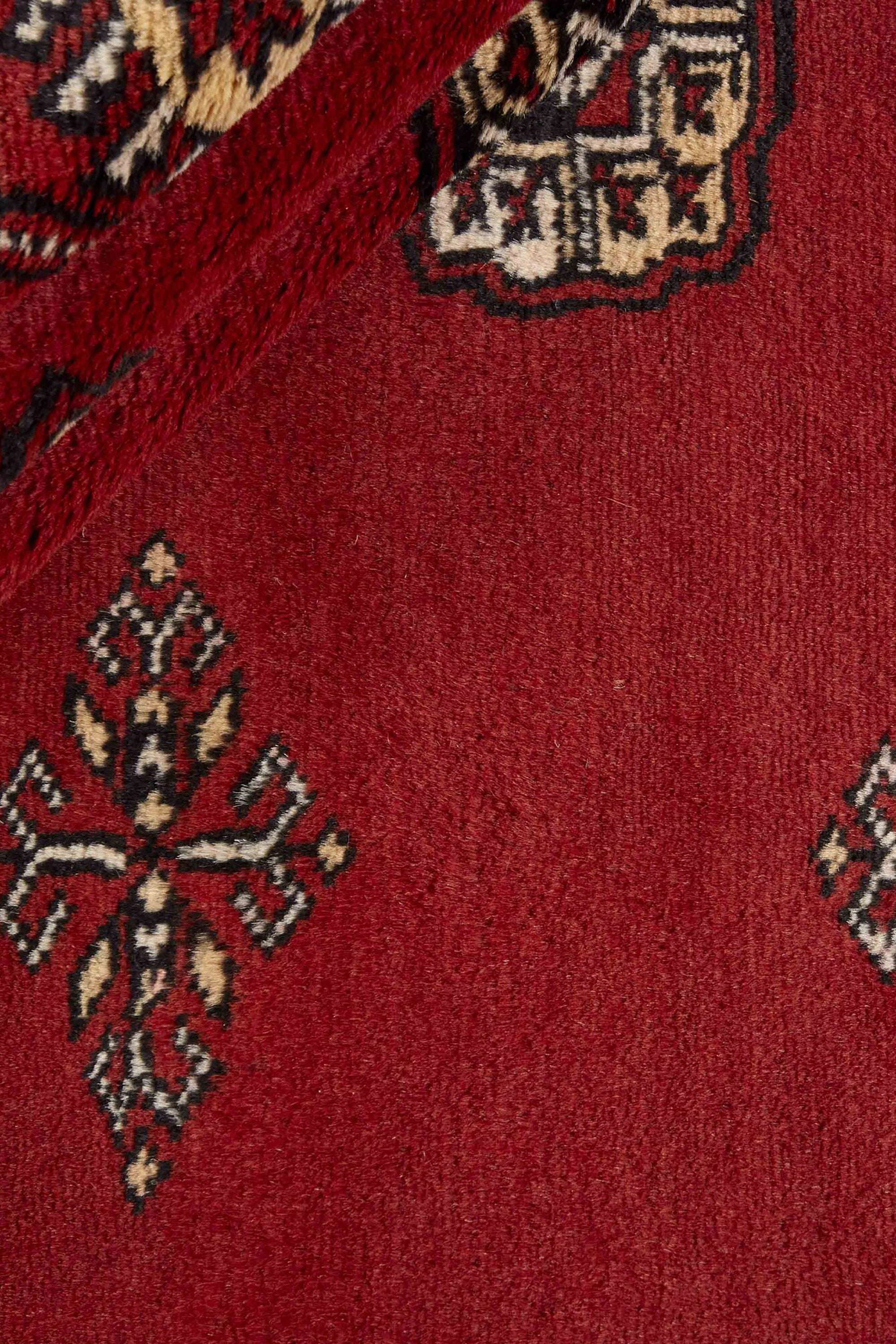 Red Oriental rug with traditional bordered pattern