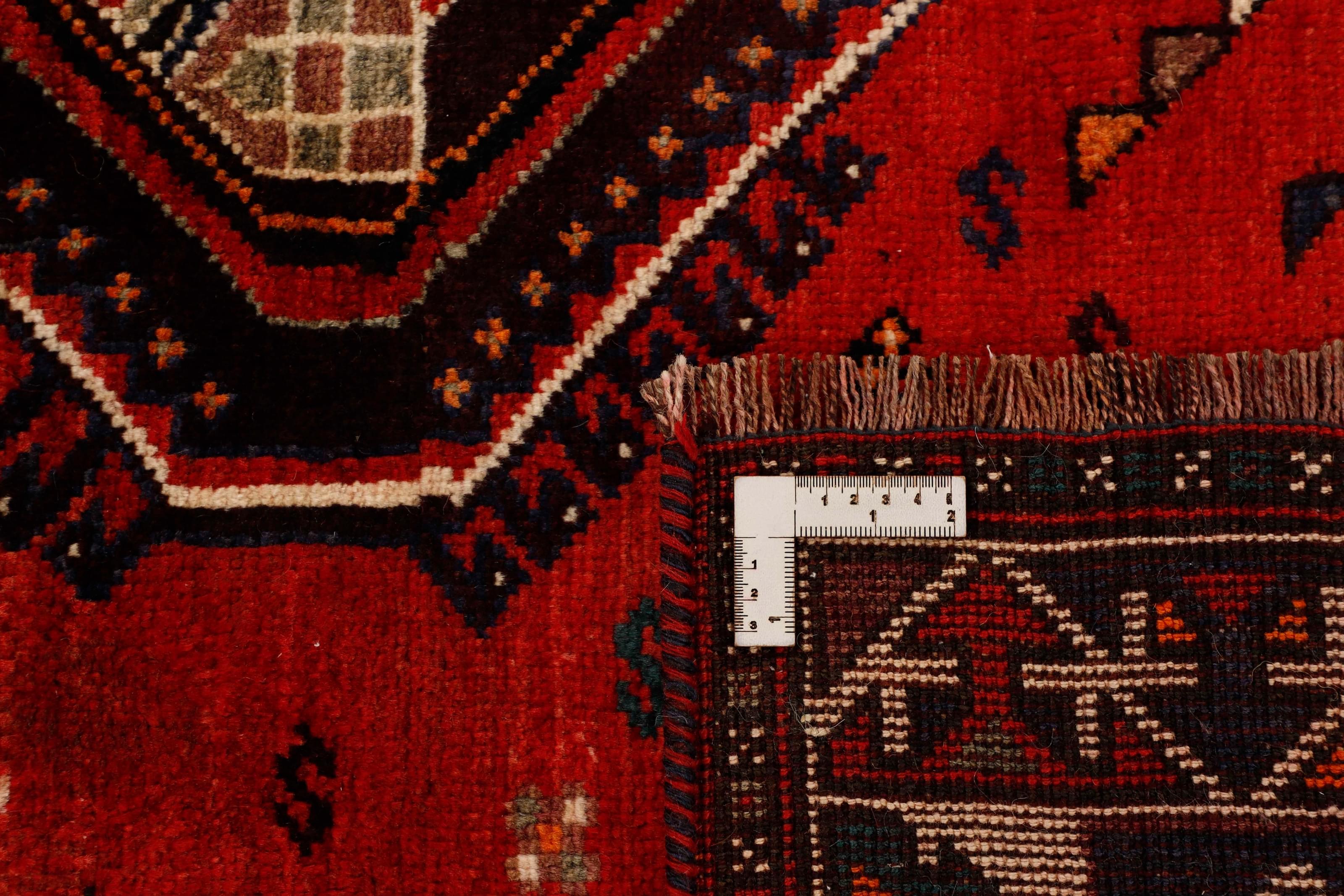 Authentic persian rug with a traditional tribal geometric pattern in red