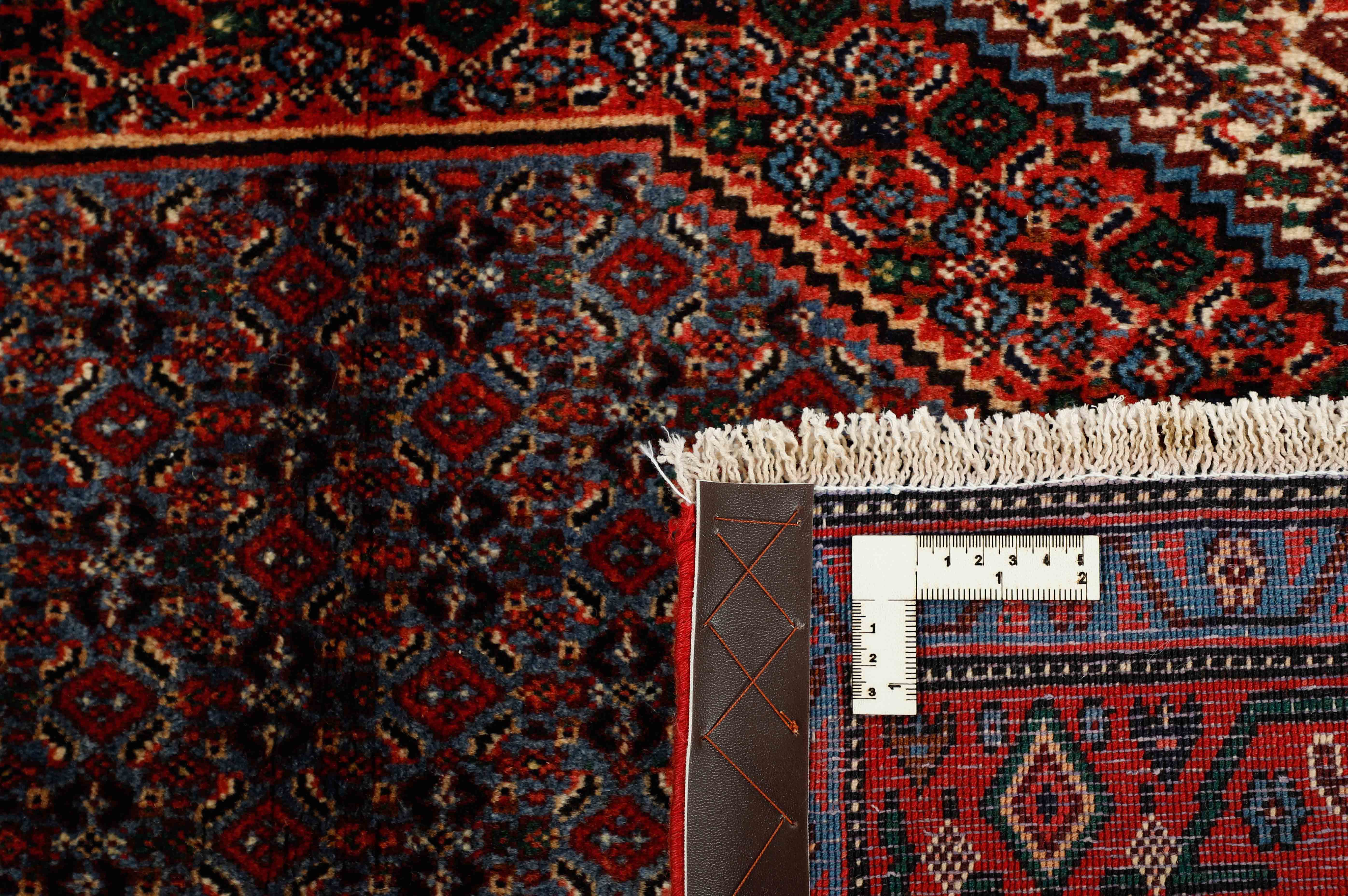authentic persian rug with a traditional geometric design in red