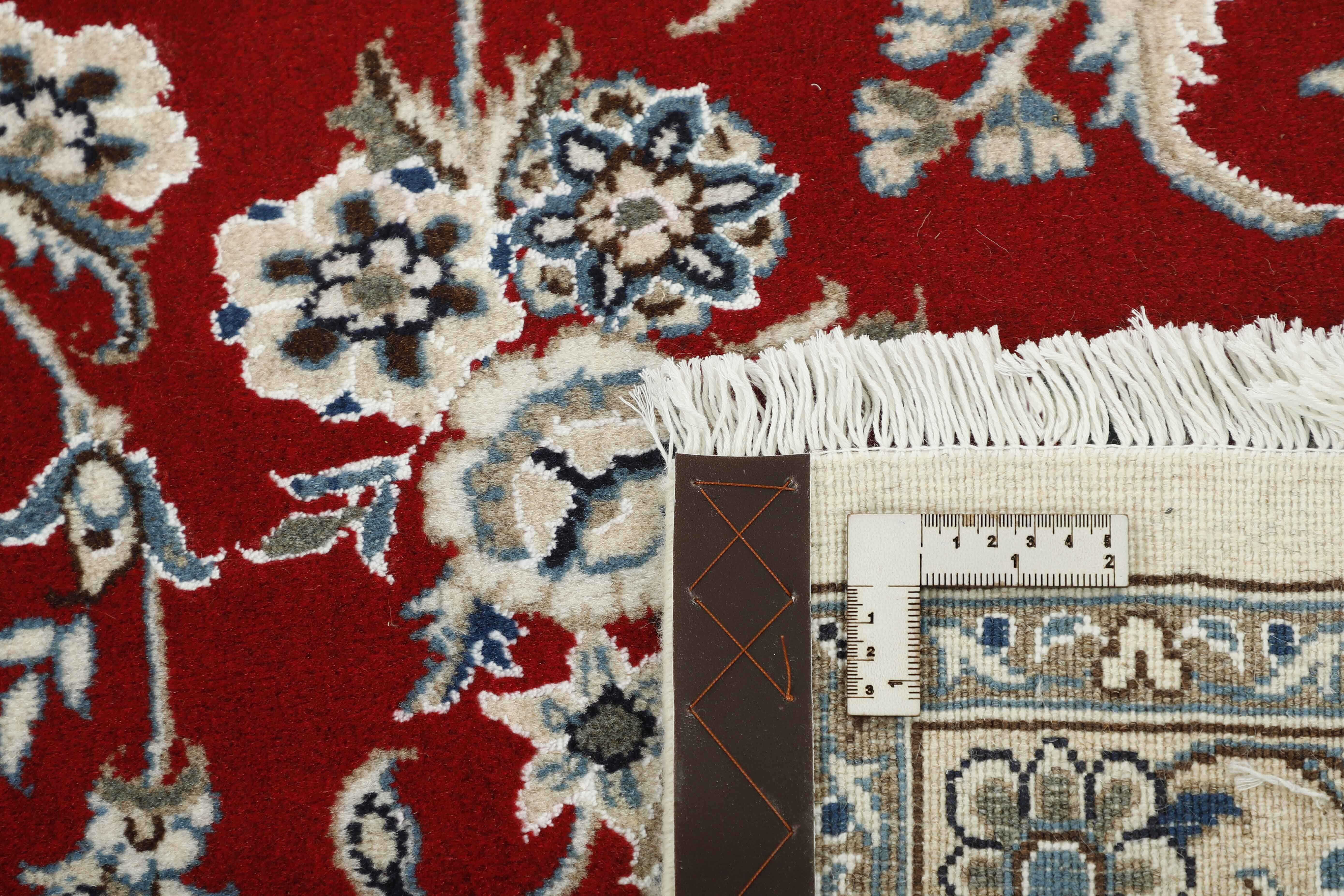 Authentic persian rug with a traditional floral design in cream and red