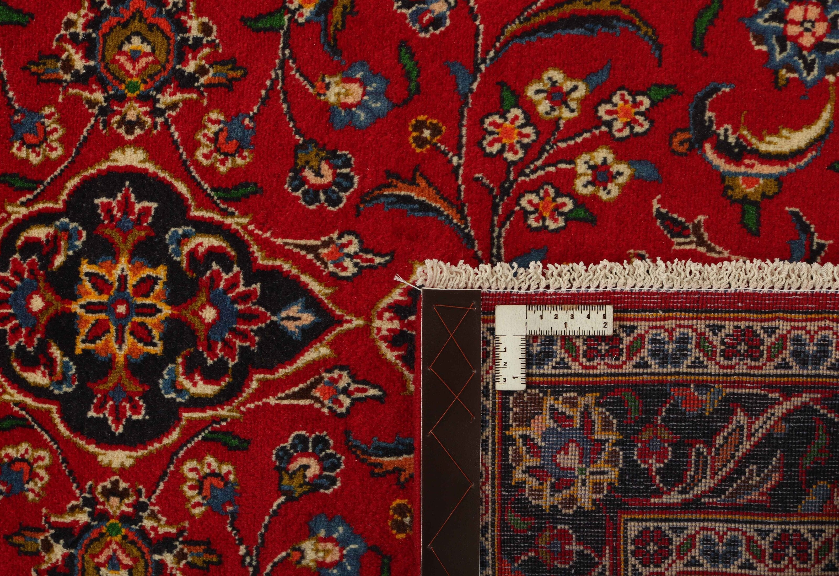 Traditional bordered Keshan rug with red background