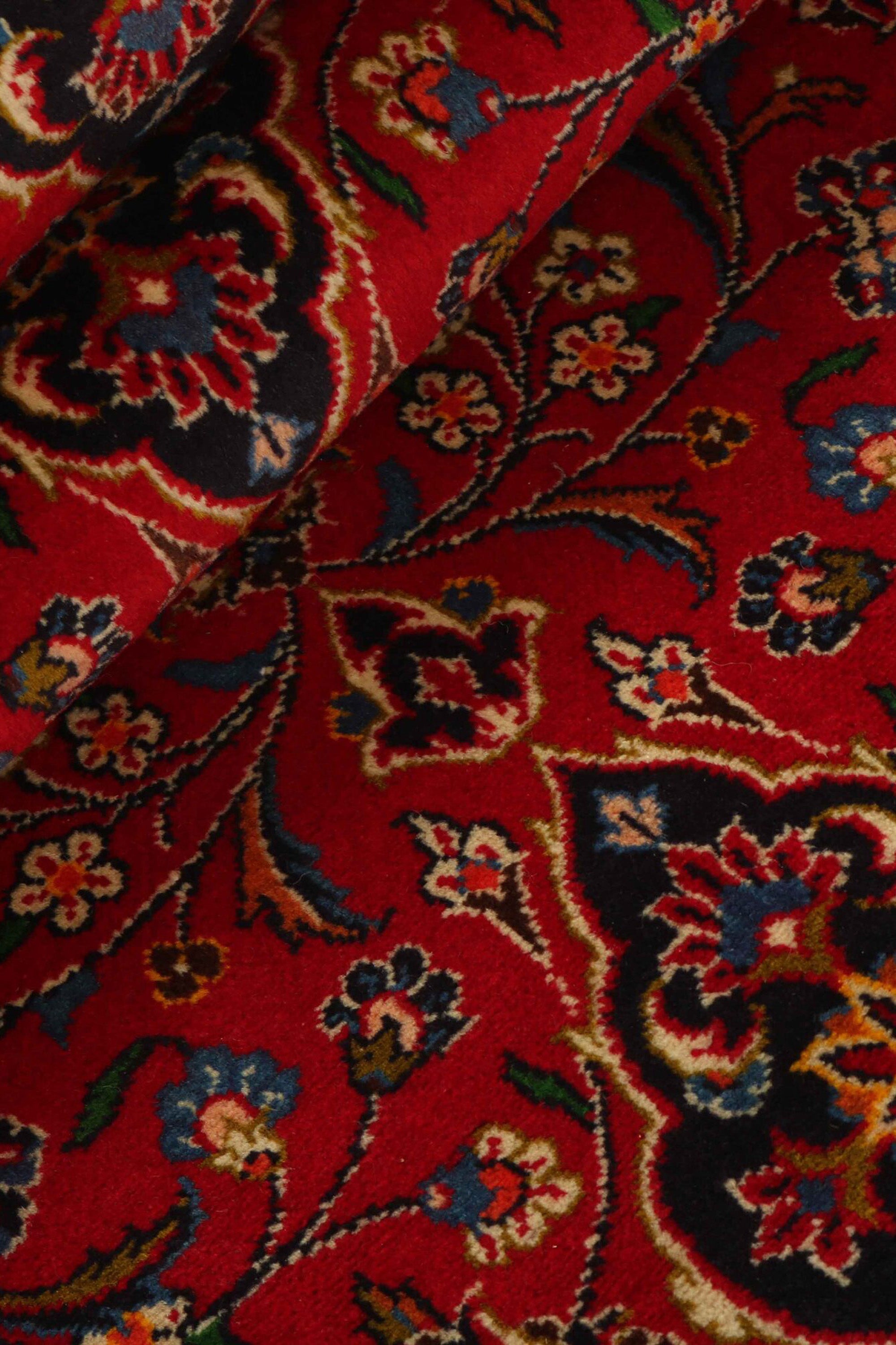 Traditional bordered Keshan rug with red background
