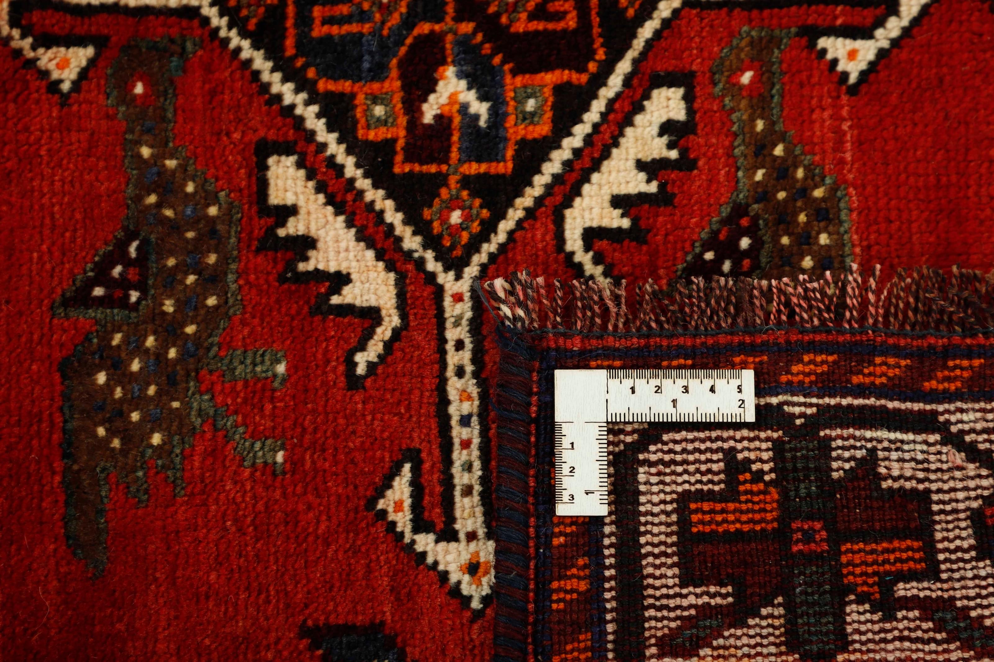 Authentic persian rug with a traditional tribal geometric pattern in red
