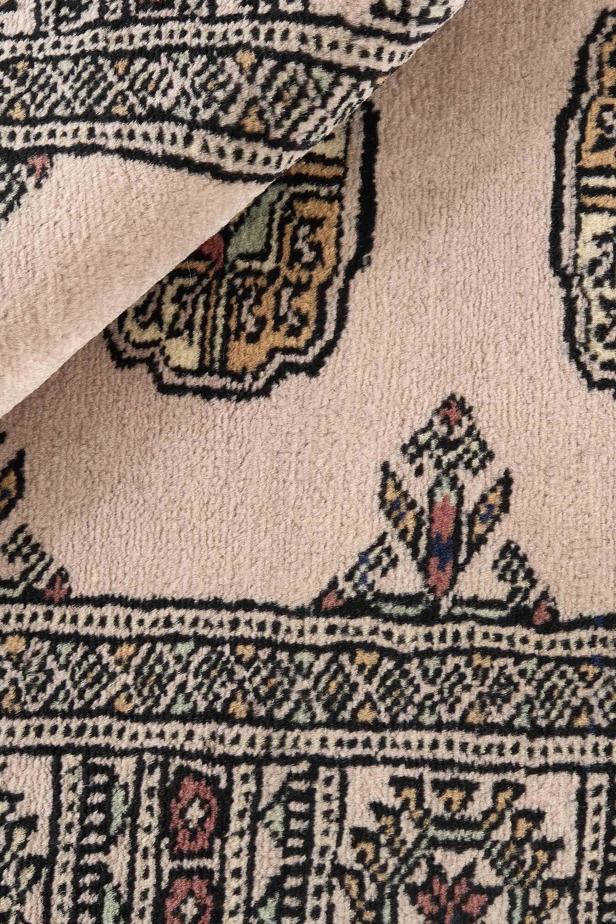 Beige Oriental rug with traditional bordered pattern
