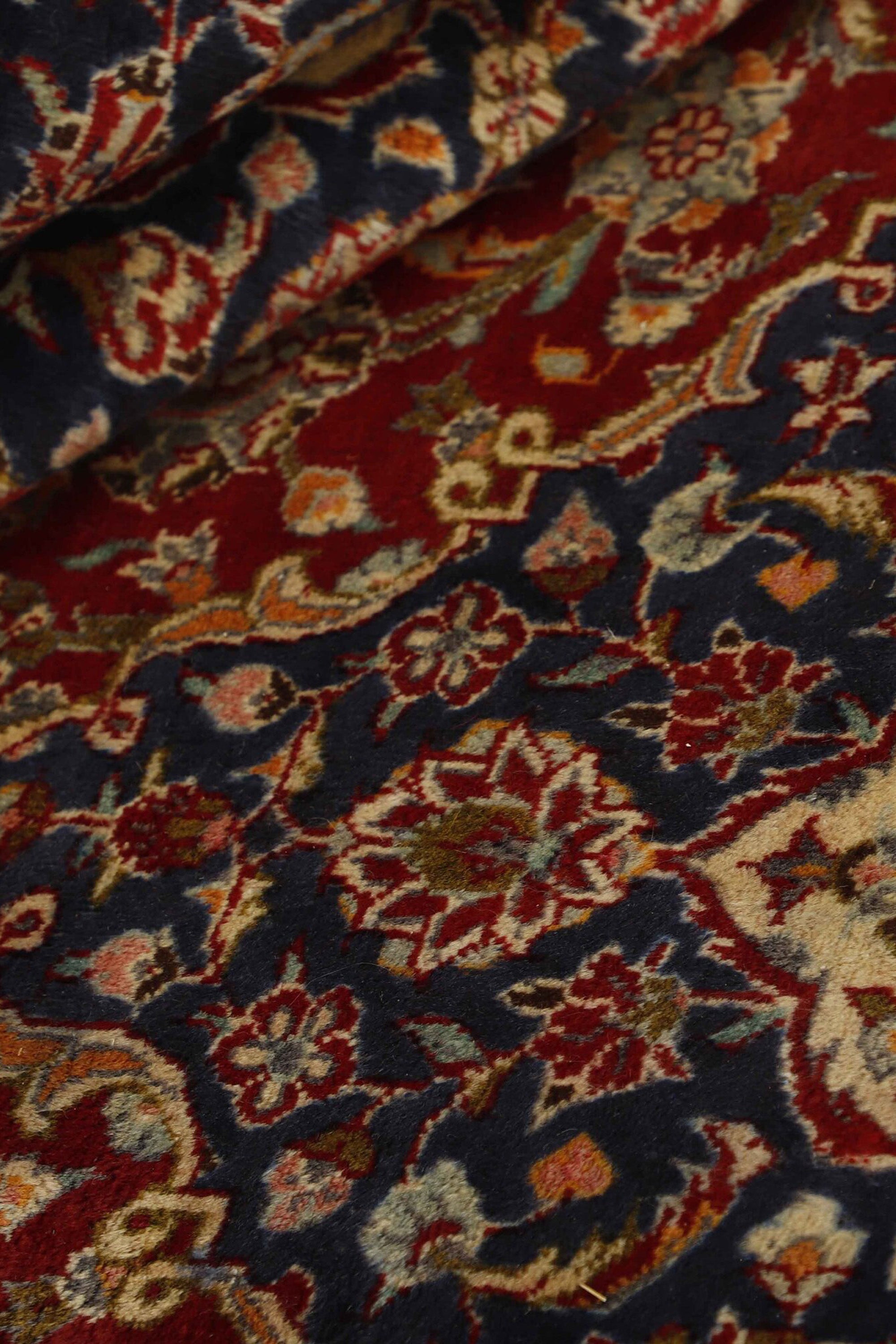 Traditional bordered Keshan rug with red background