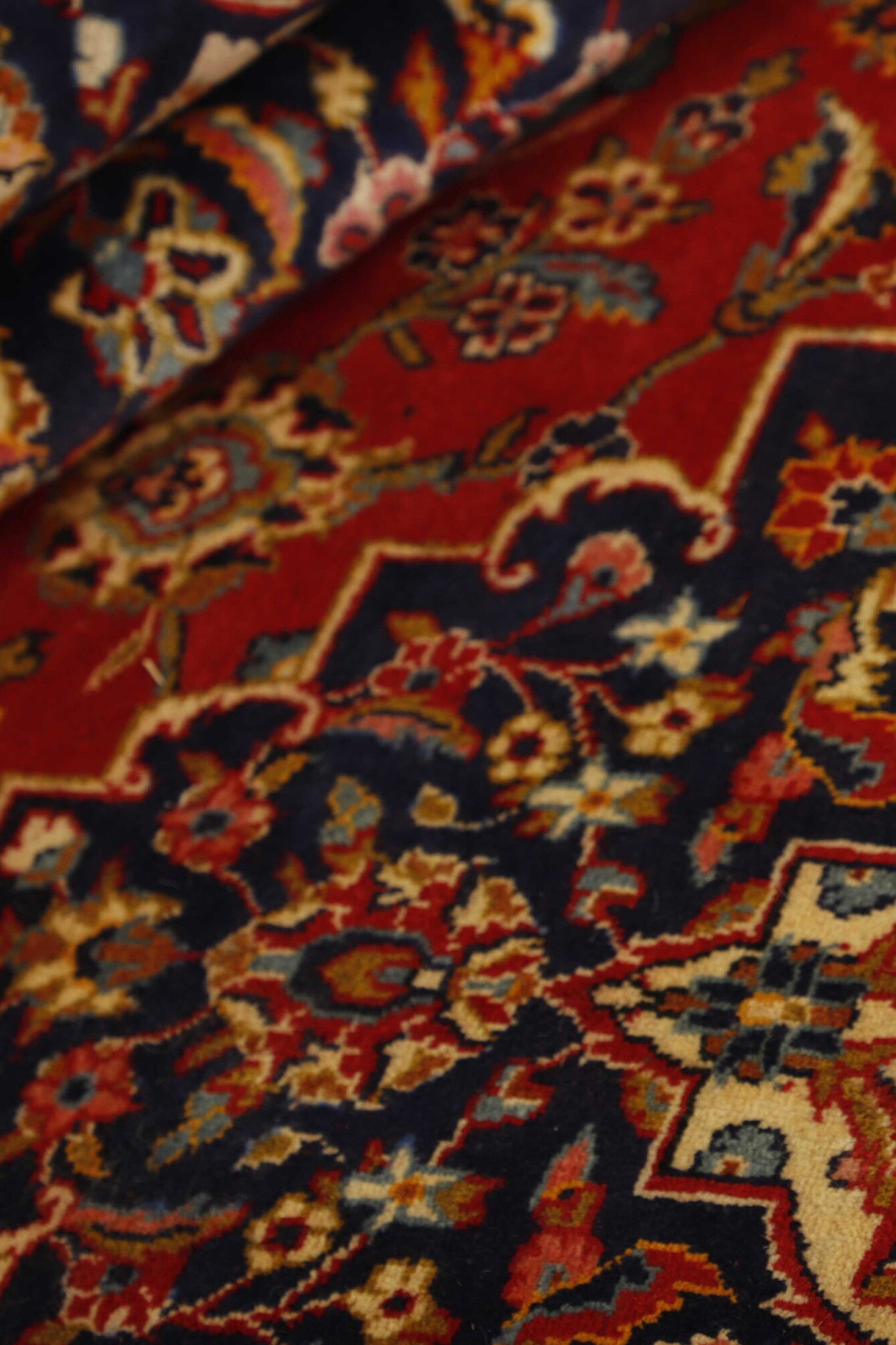 Traditional bordered Keshan rug with red background