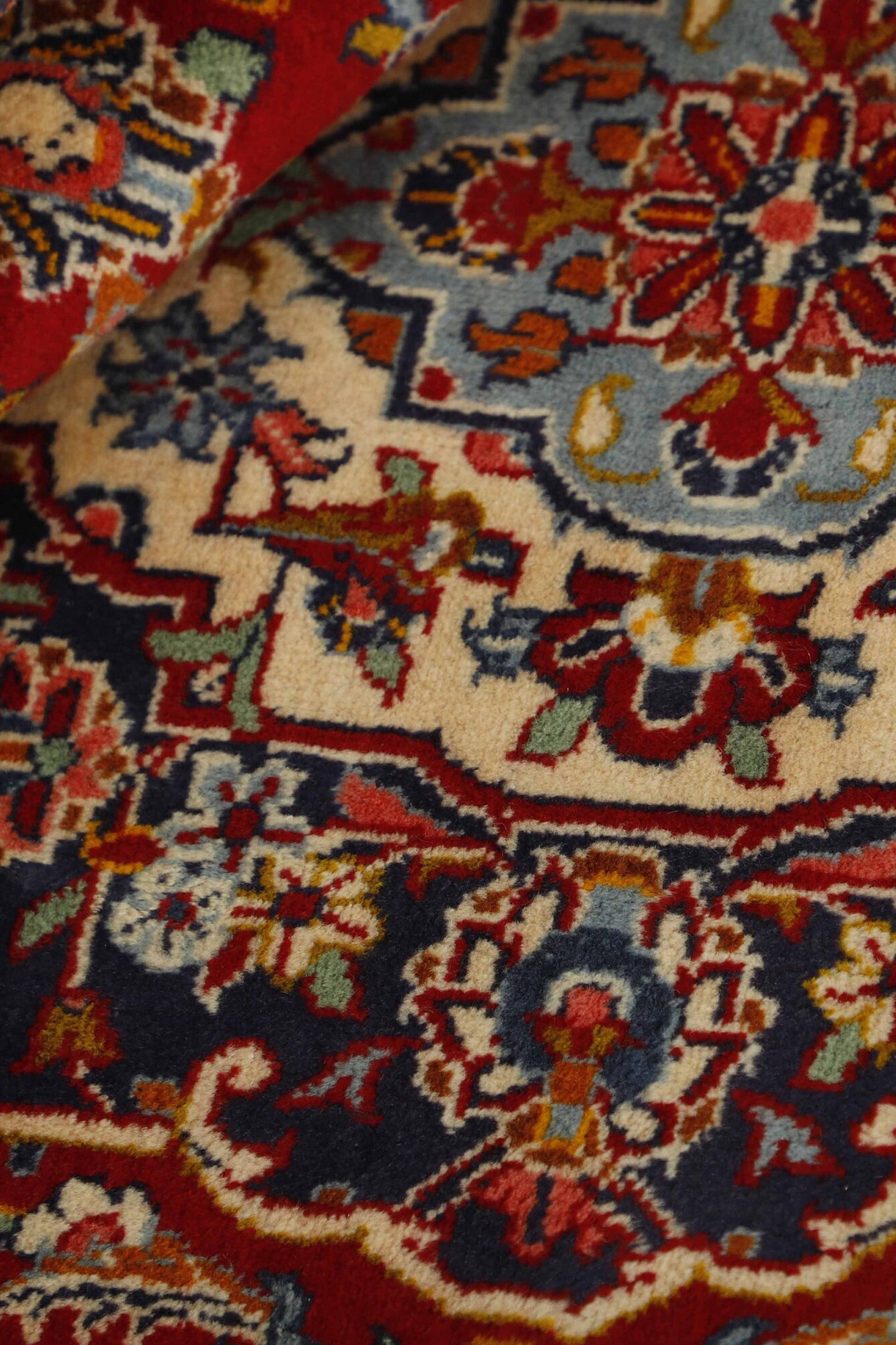 Traditional bordered Keshan rug with red background