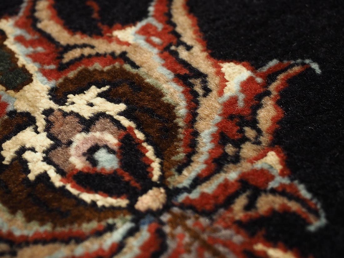 Red and black persian rug with traditional floral design