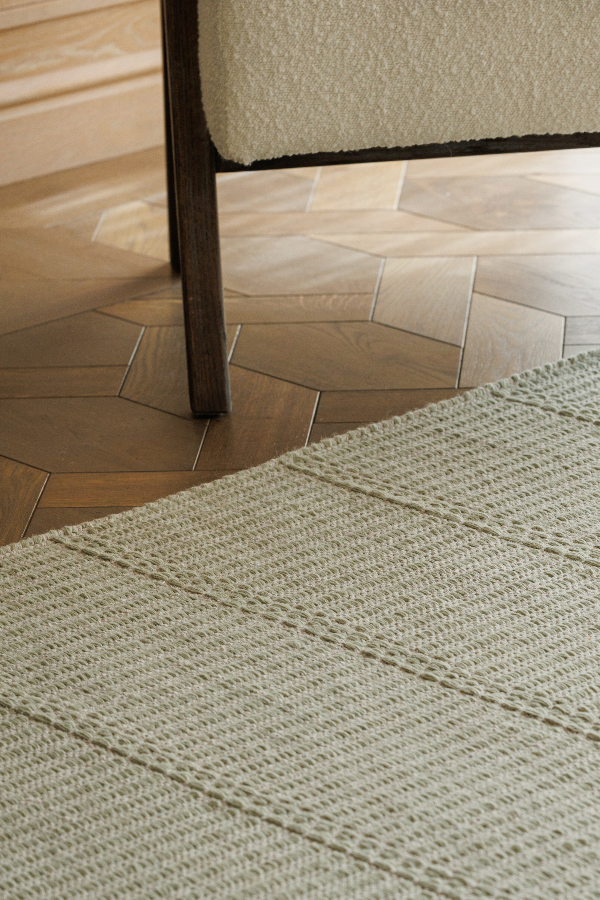 wool and cotton rug in soft olive hues featuring a design inspired by ancient irish script