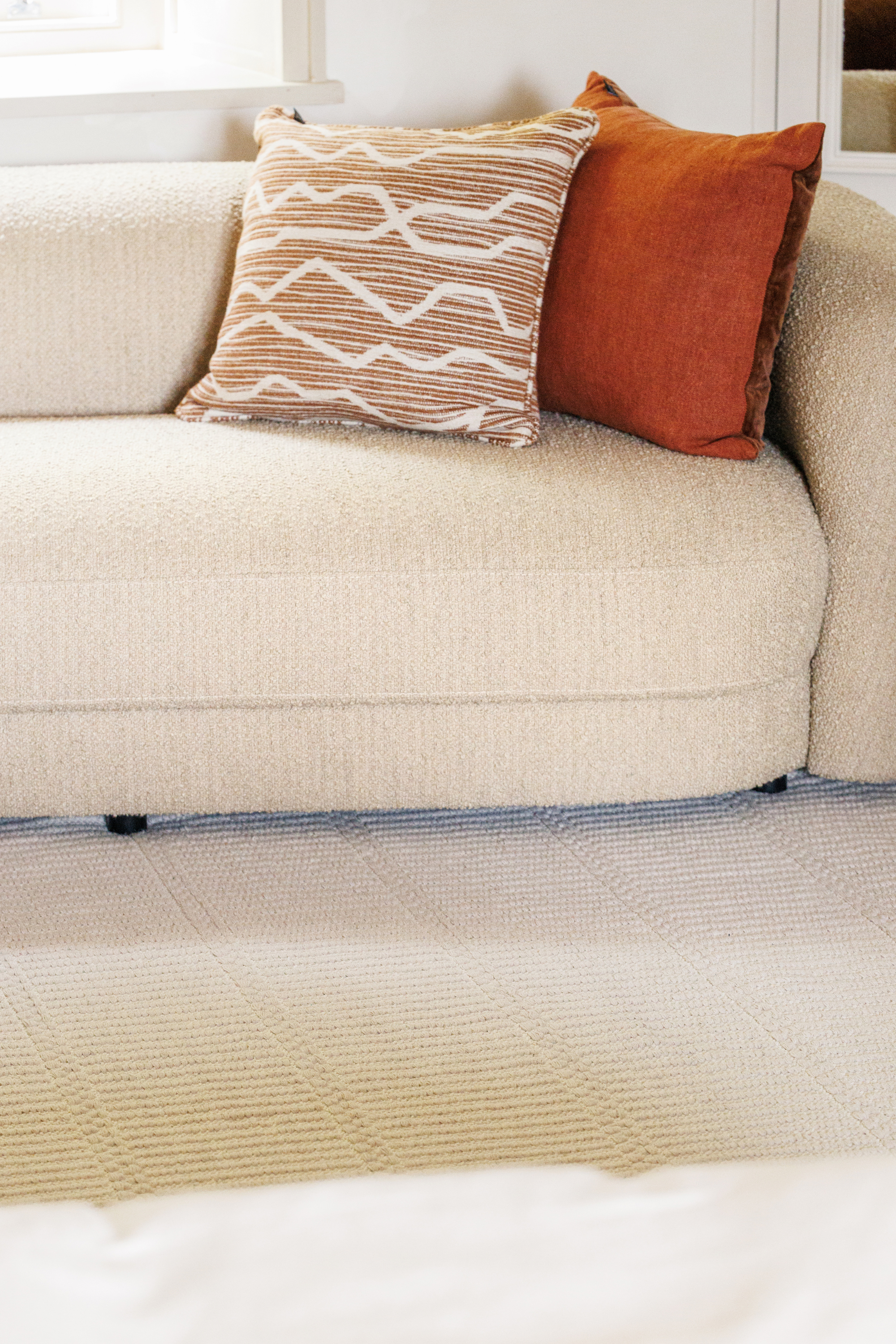 beige wool and cotton rug featuring a design inspired by ancient irish script placed under a couch