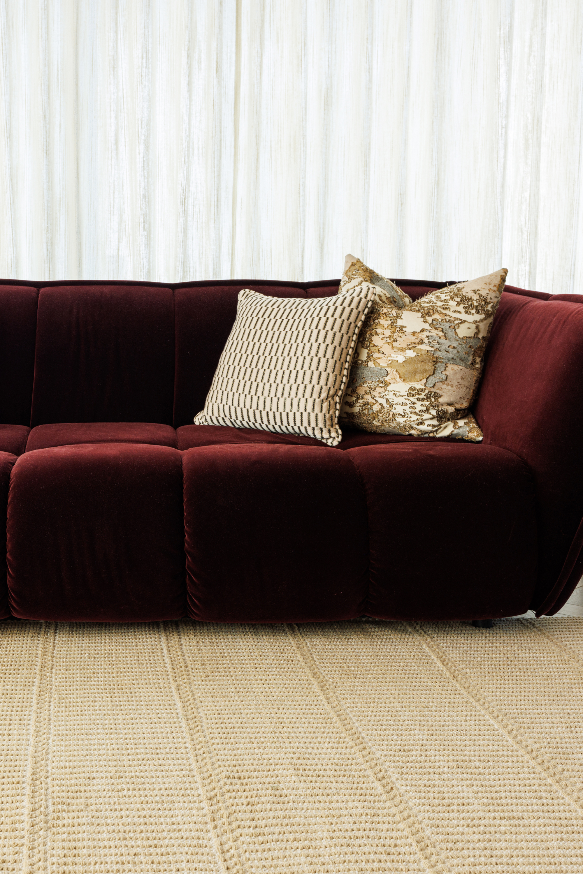 wool and cotton rug in a golden straw tone featuring a design inspired by ancient irish script placed under a couch in a living room