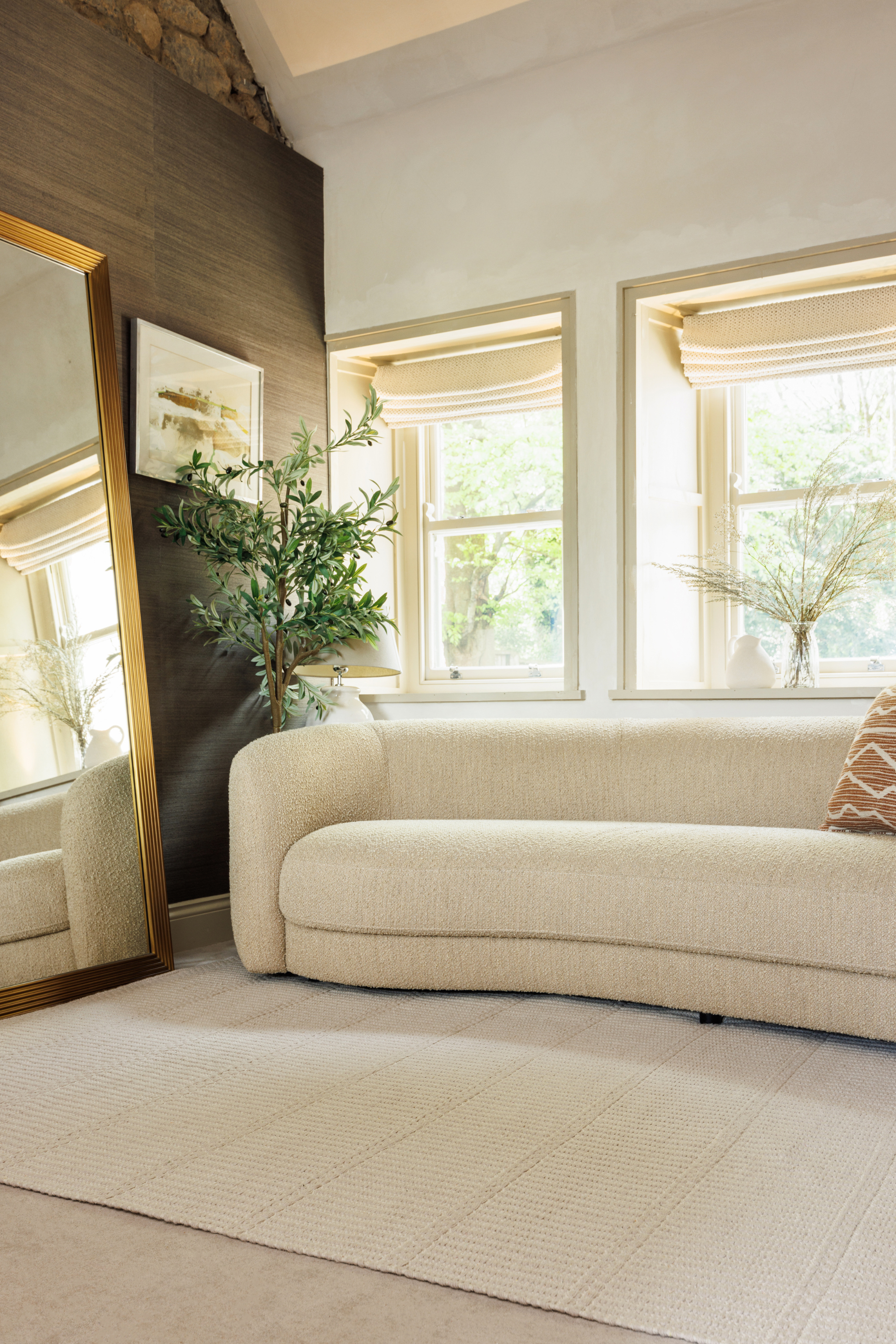 beige wool and cotton rug featuring a design inspired by ancient irish script placed under a couch in a living room