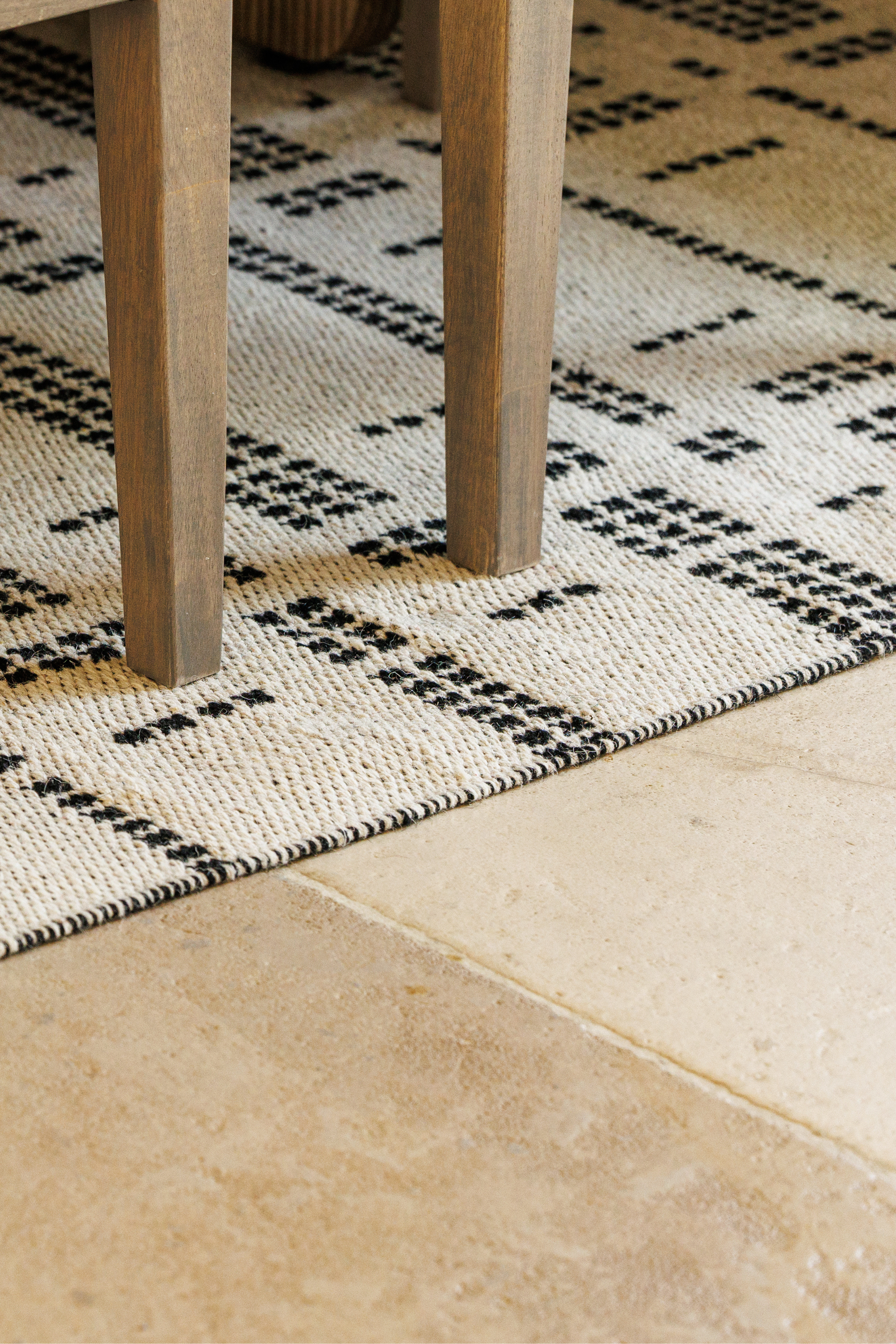 White wool and cotton rug with a black geometric pattern inspired by the Manhattan skyline at night