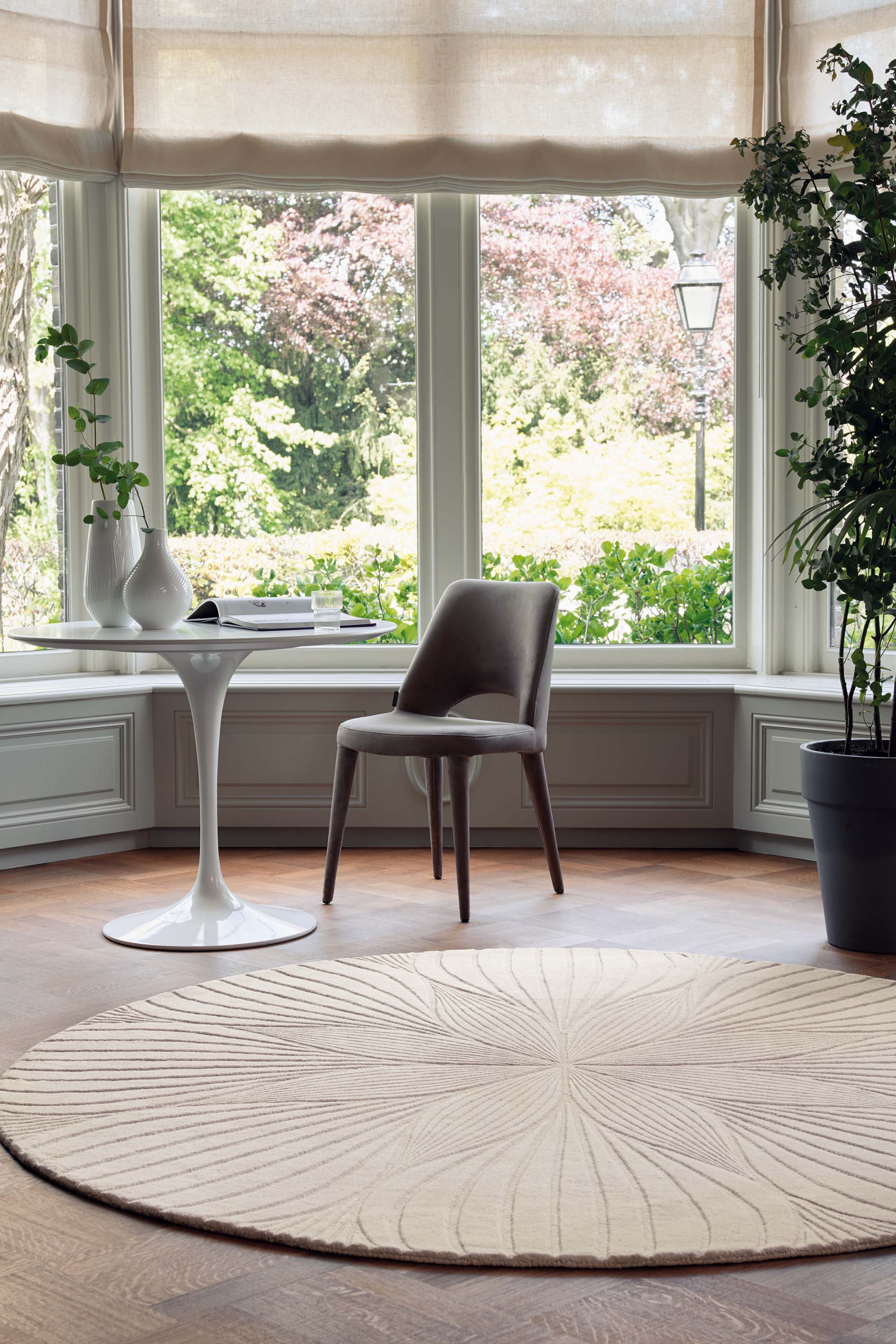 Round beige rug with engraved floral botanical pattern