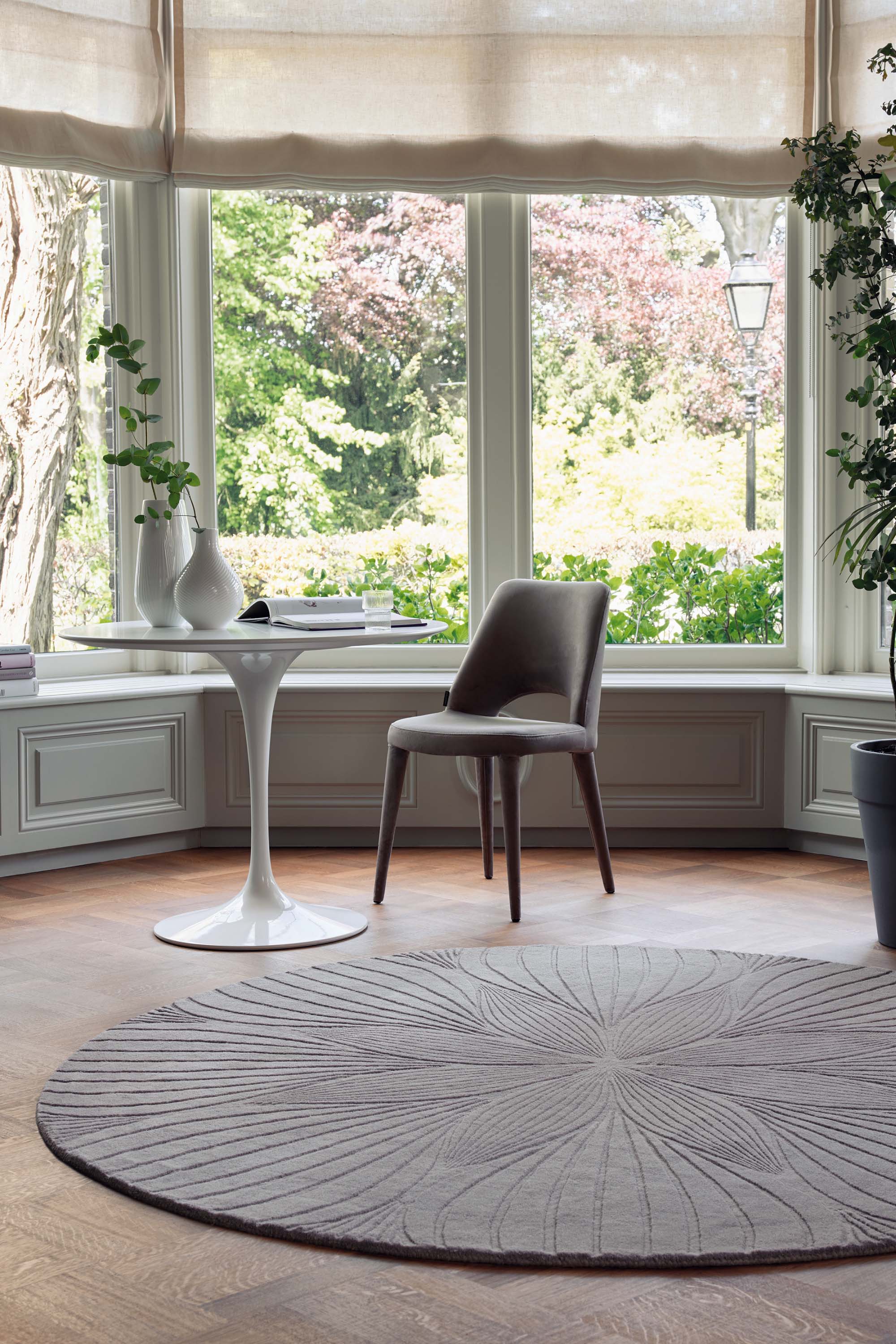 Round grey rug with engraved botanical pattern