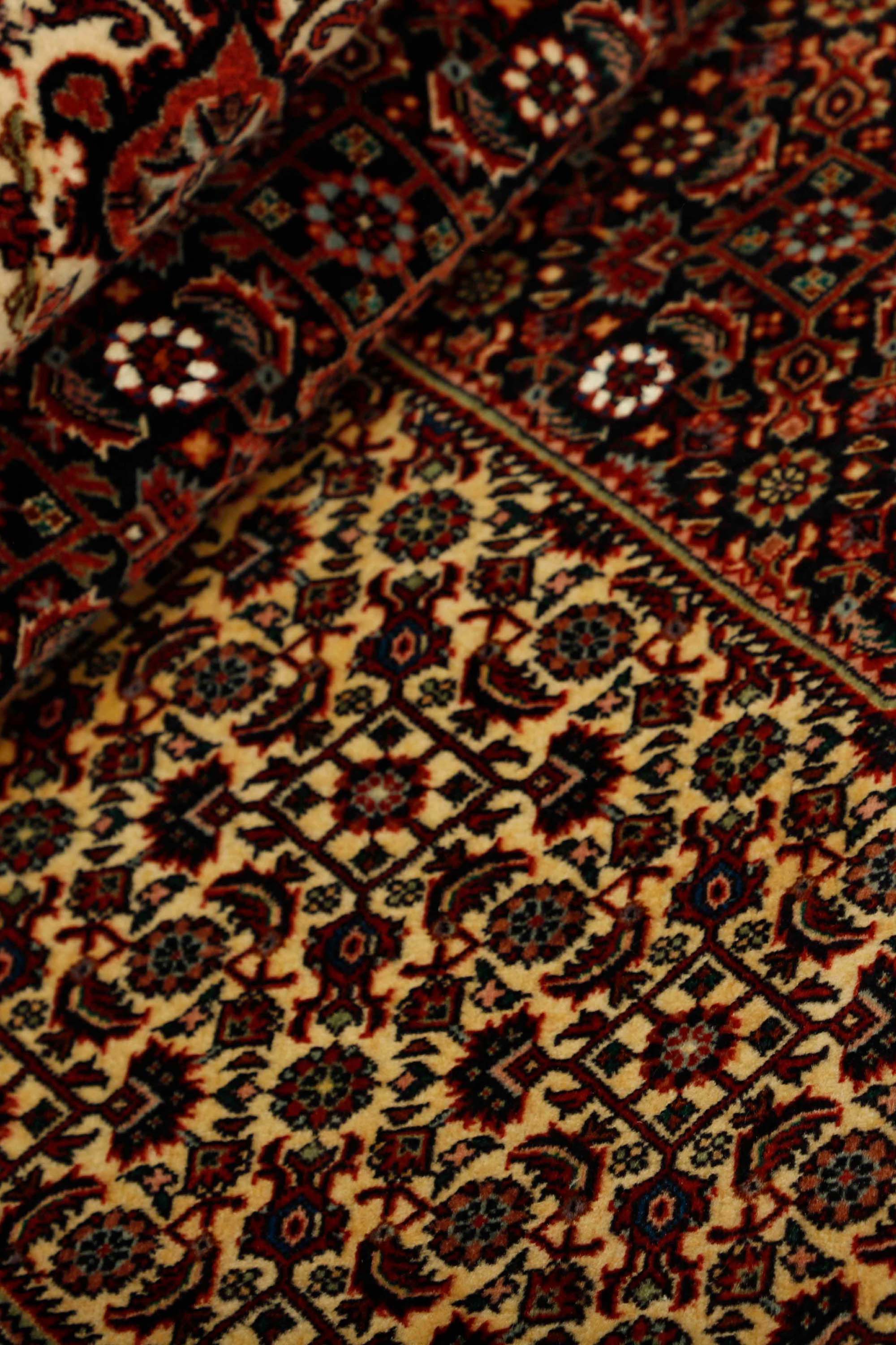 Traditional bordered Bidjar rug in red, cream, and black tones