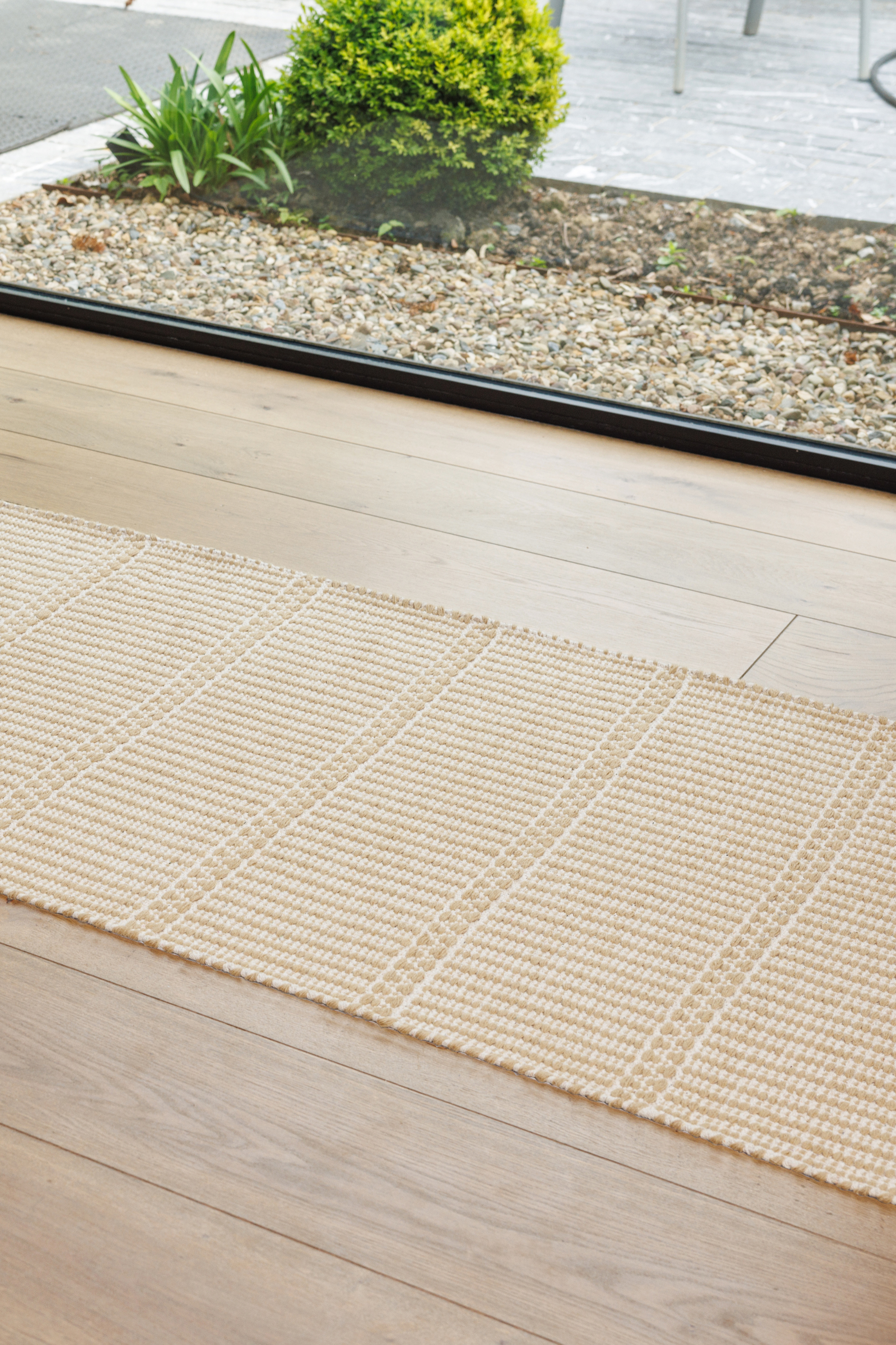 wool and cotton runner rug in a golden straw tone featuring a design inspired by ancient irish script placed in a hallway