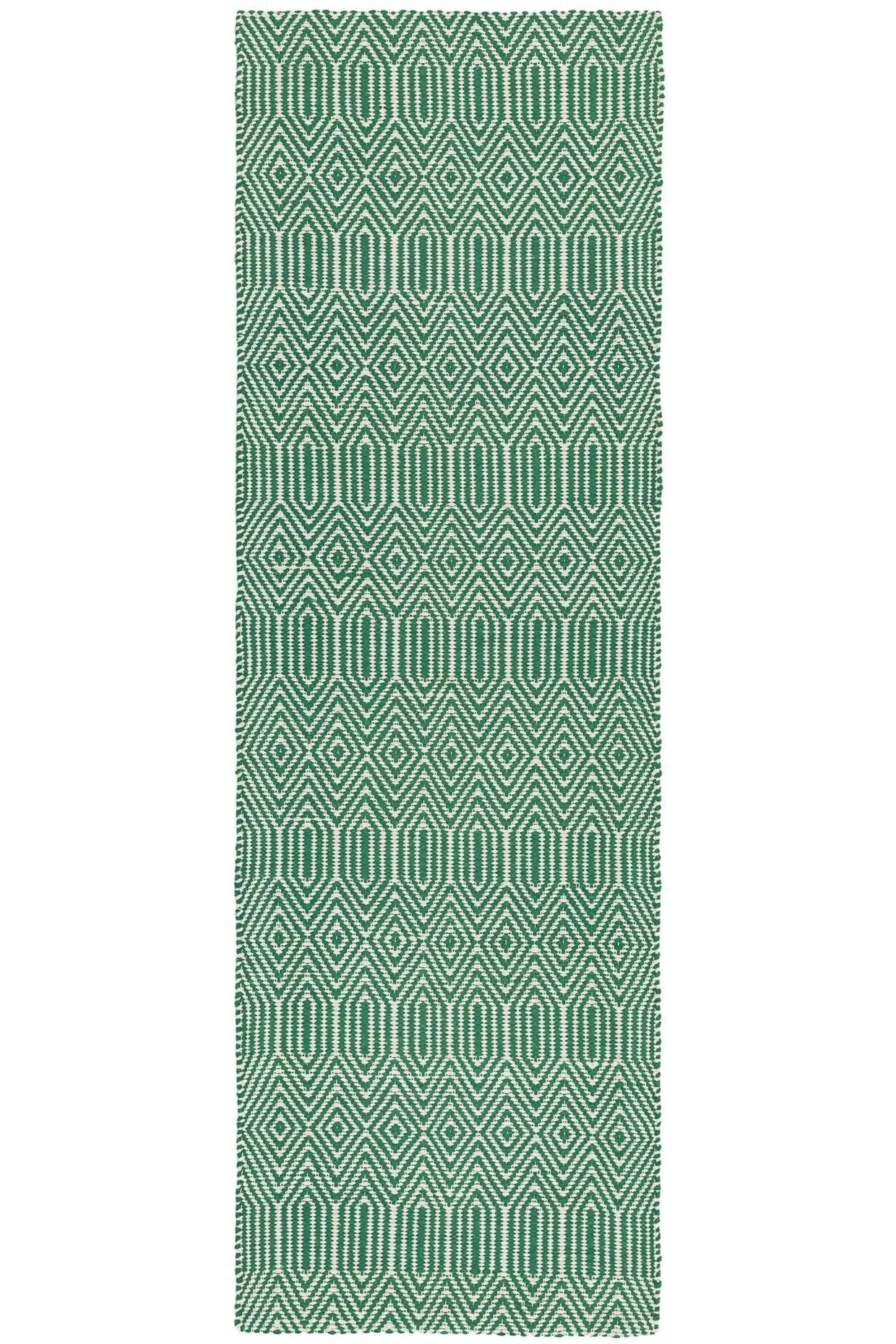 green and white runner with a geometric aztec design