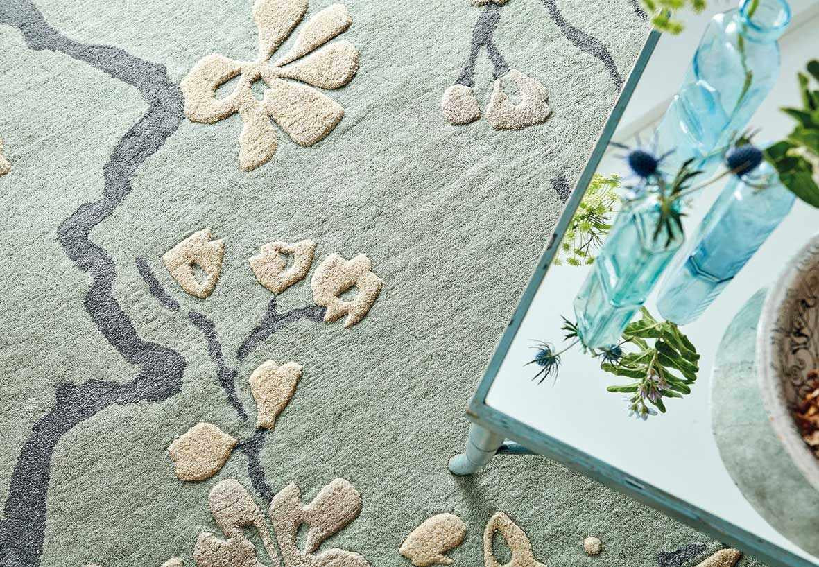 Rectangular blue rug with dark blue branch design and white flowers and leaves
