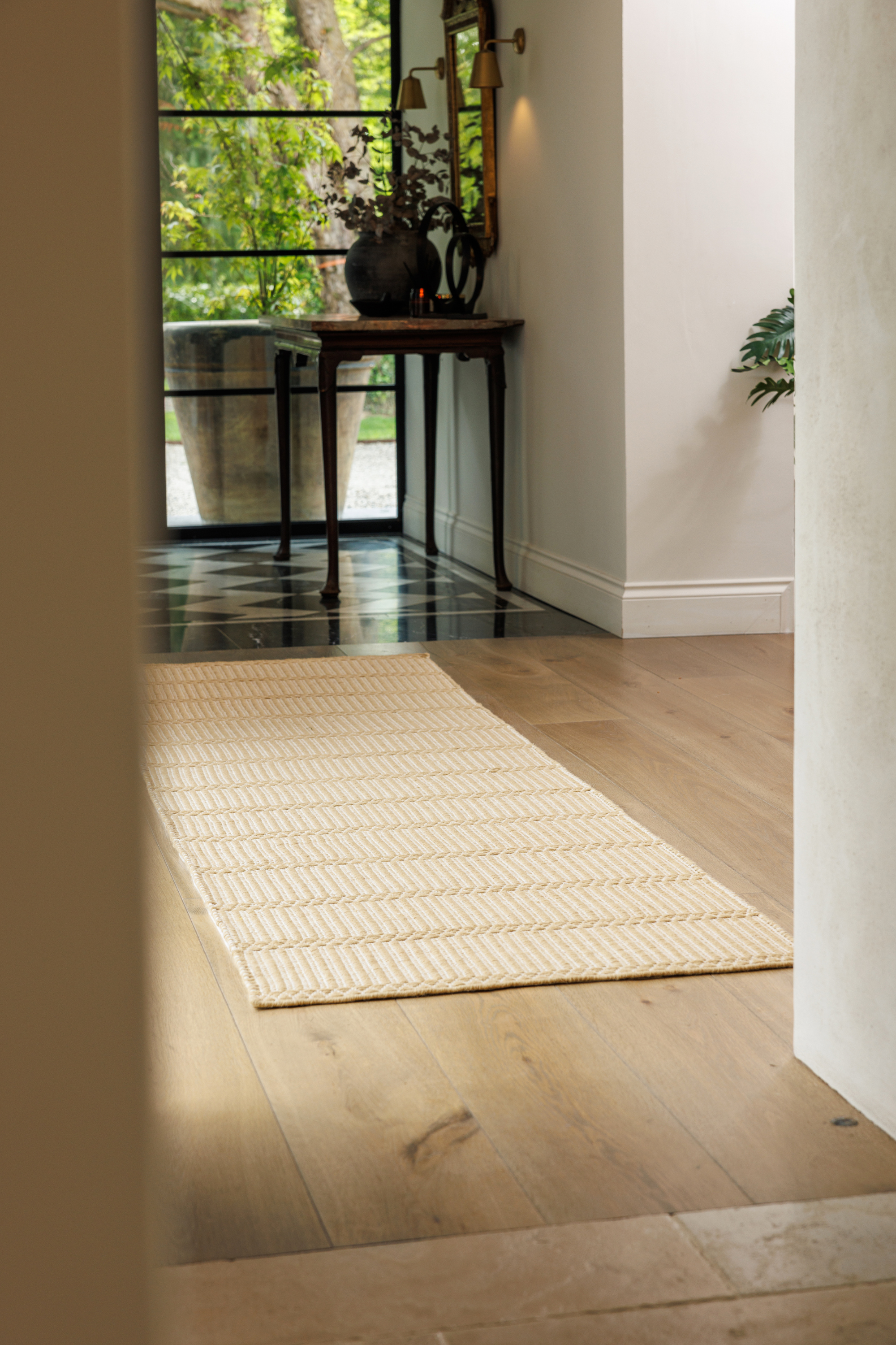 wool and cotton runner rug in a golden straw tone featuring a design inspired by ancient irish script placed in a hallway