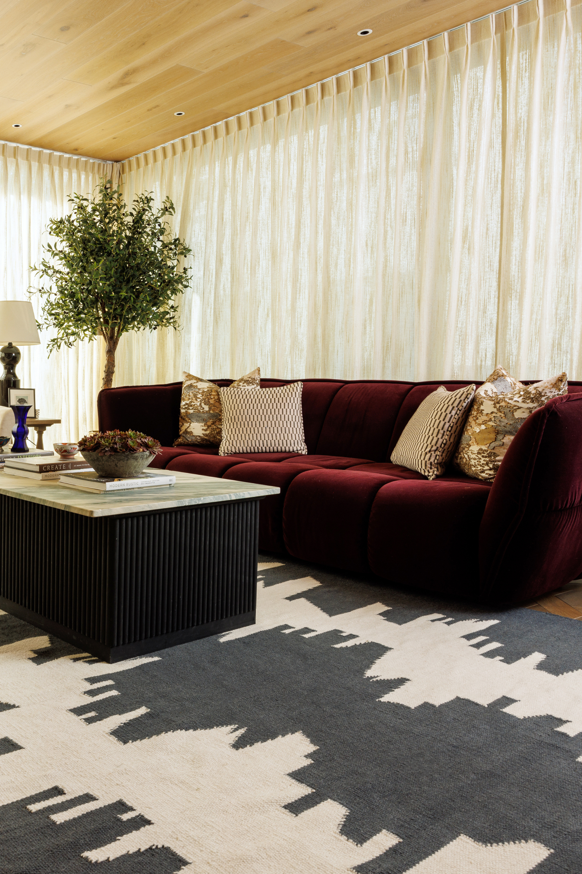 a black and white wool and cotton rug featuring a monochromatic modern abstract design placed under a couch in a living room