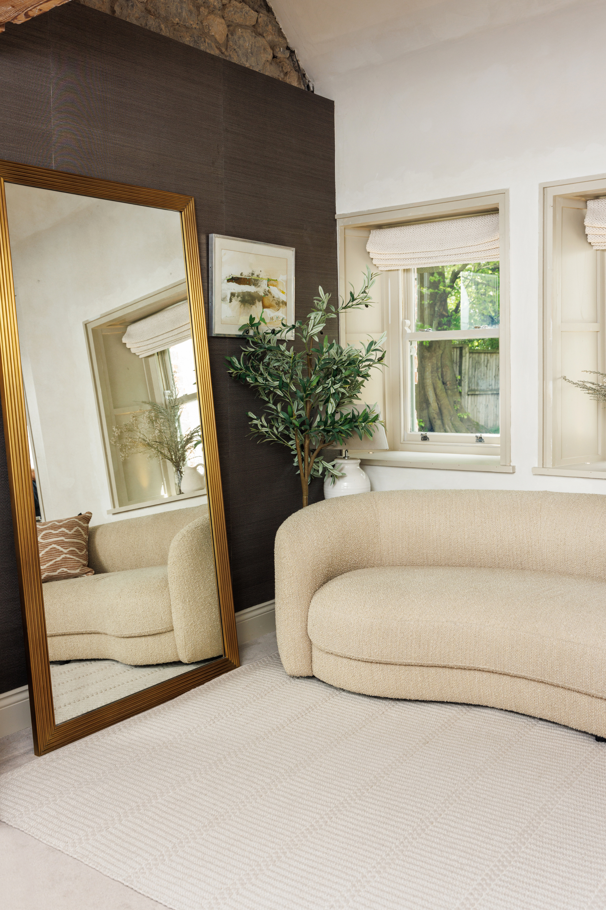 beige wool and cotton rug featuring a design inspired by ancient irish script placed under a couch in a living room