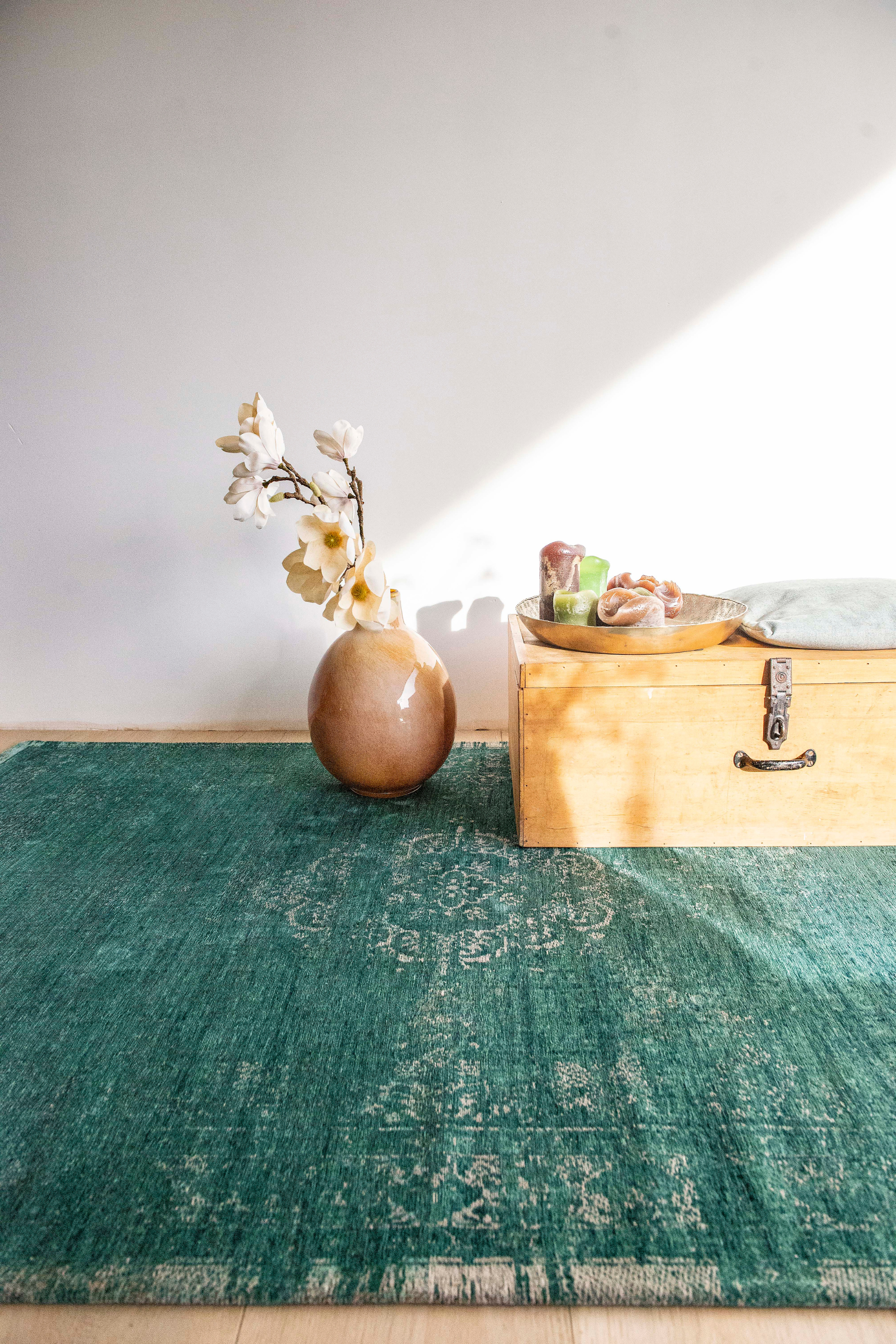 green flatweave rug with faded persian design