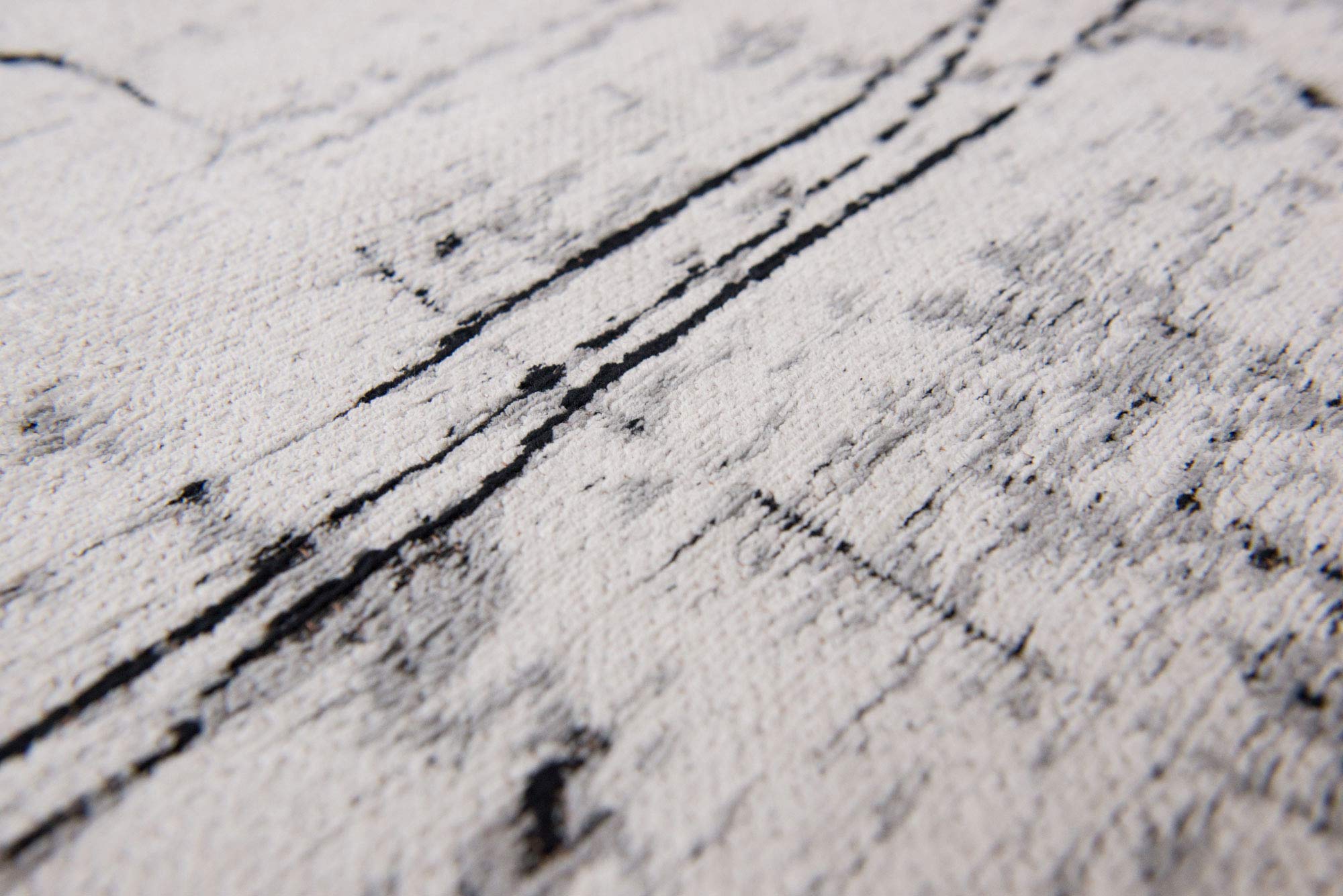 White flatweave rug with grey and black abstract pattern