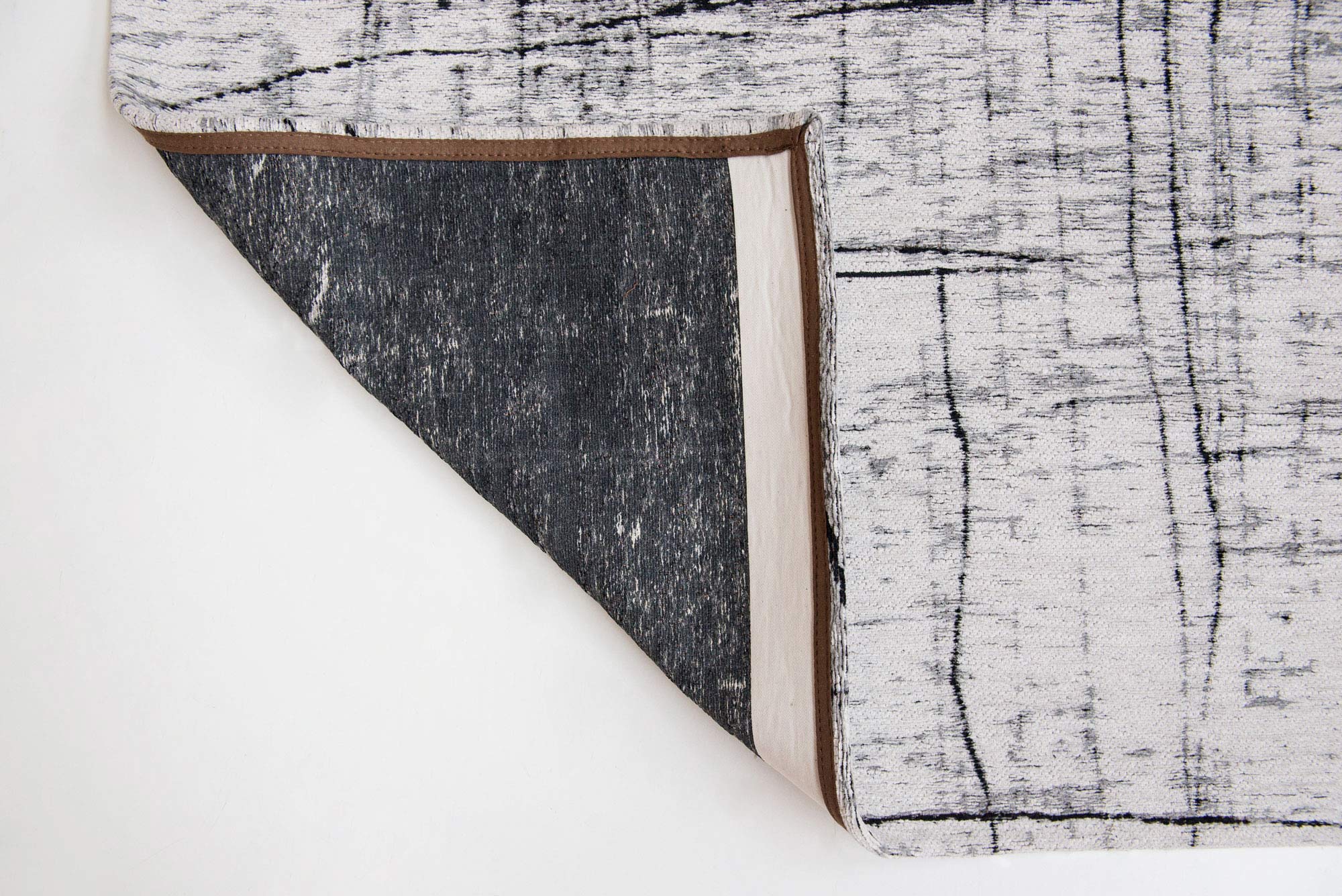 White flatweave rug with grey and black abstract pattern