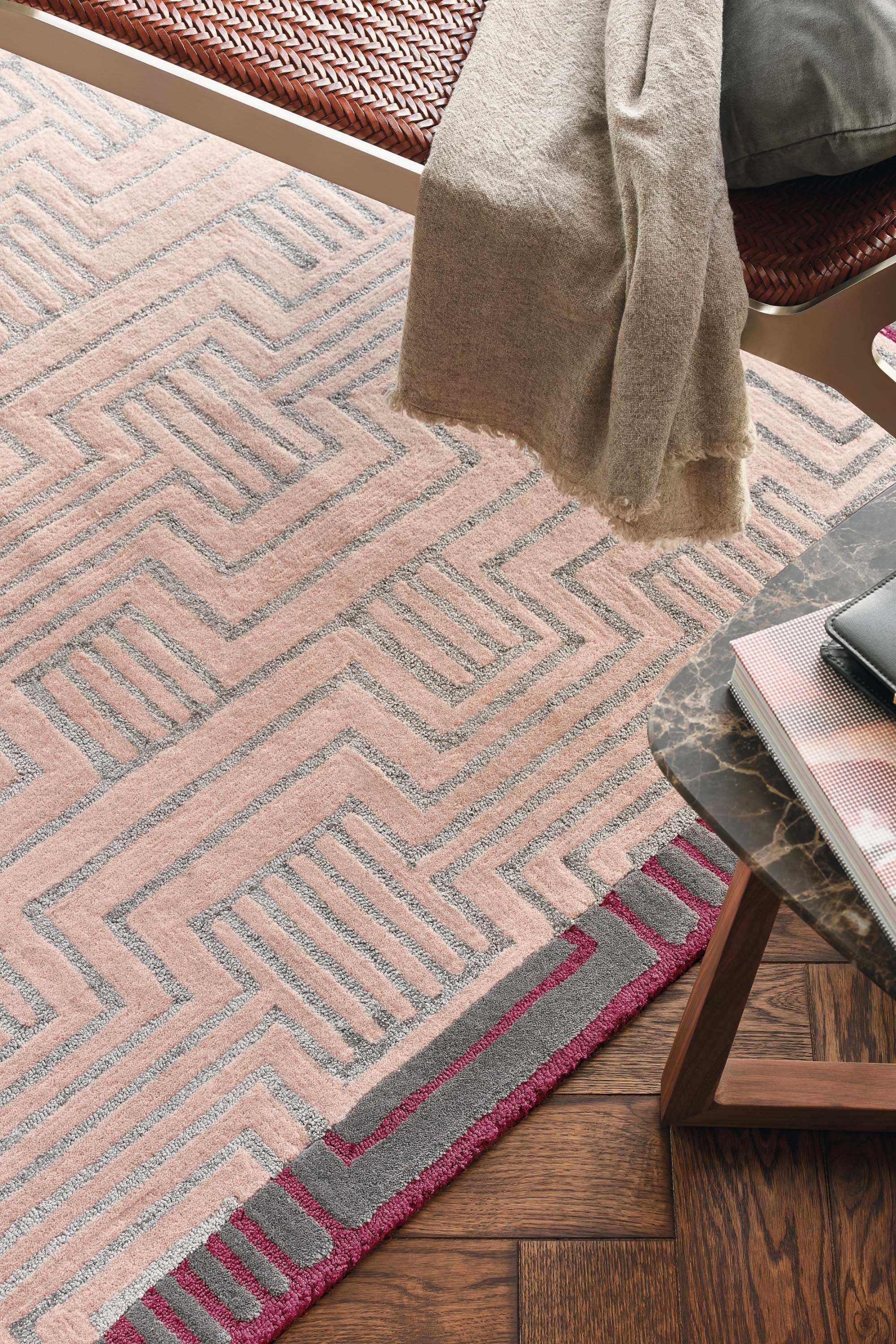 Rectangular pink rug with burgundy border and grey art deco pattern
