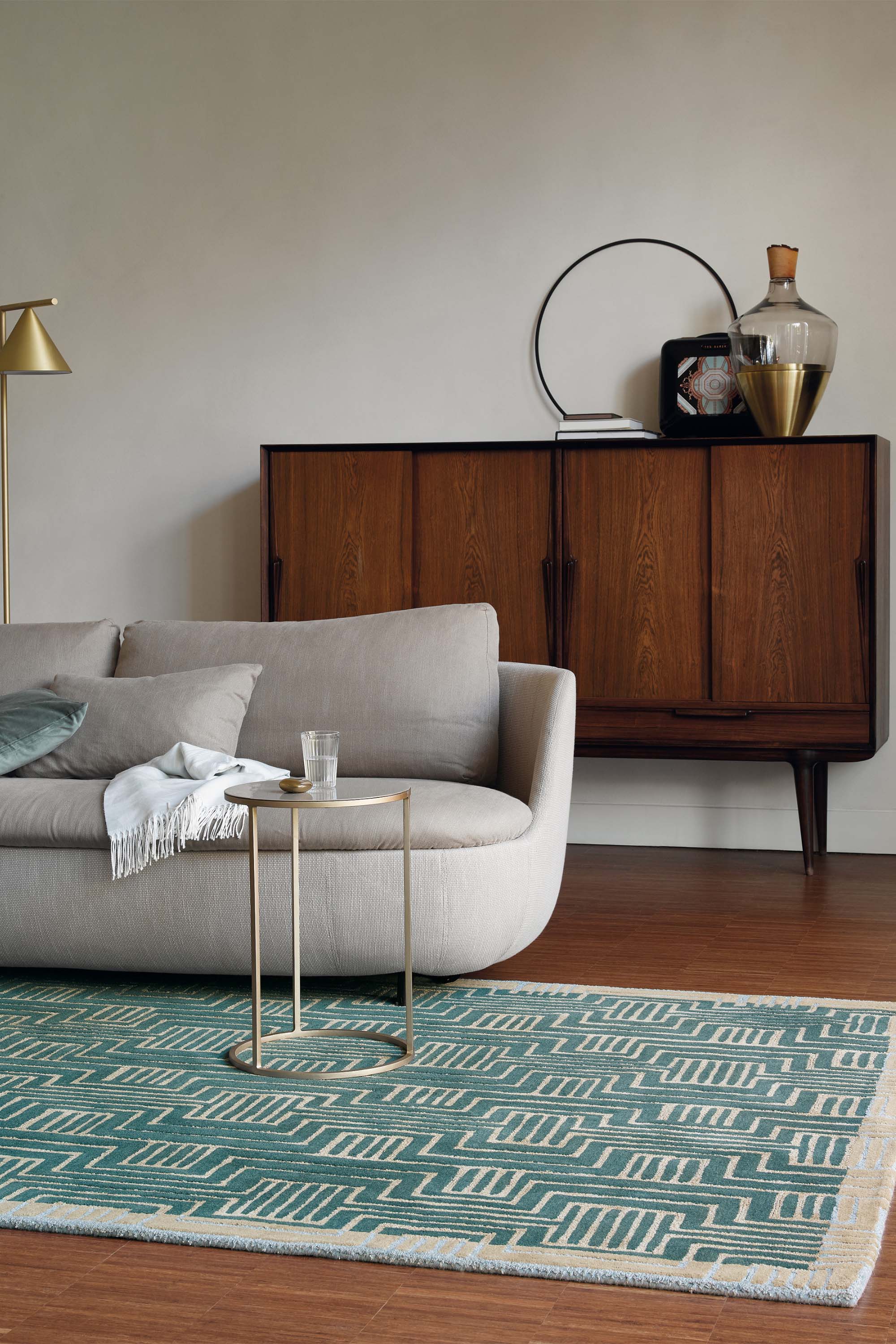 Rectangular green rug with beige border and grey art deco pattern