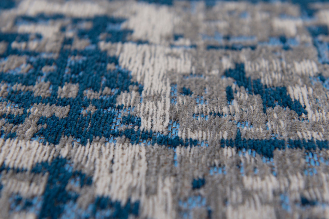 White flatweave rug with grey and blue abstract pattern