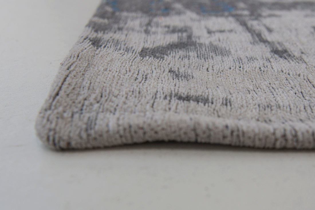 White flatweave rug with grey and blue abstract pattern
