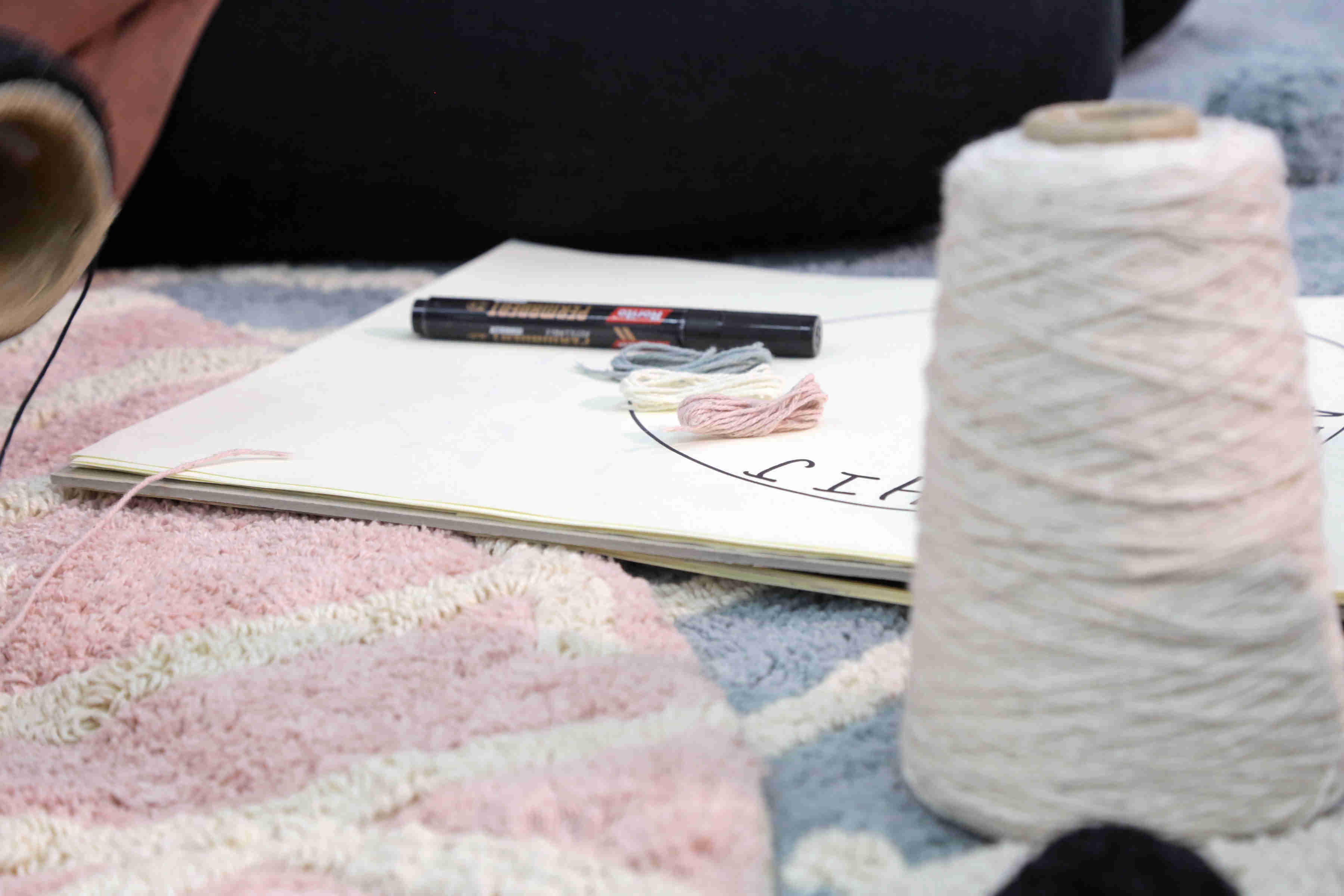 Circular pink cotton rug decorated with a natural beige alphabet border