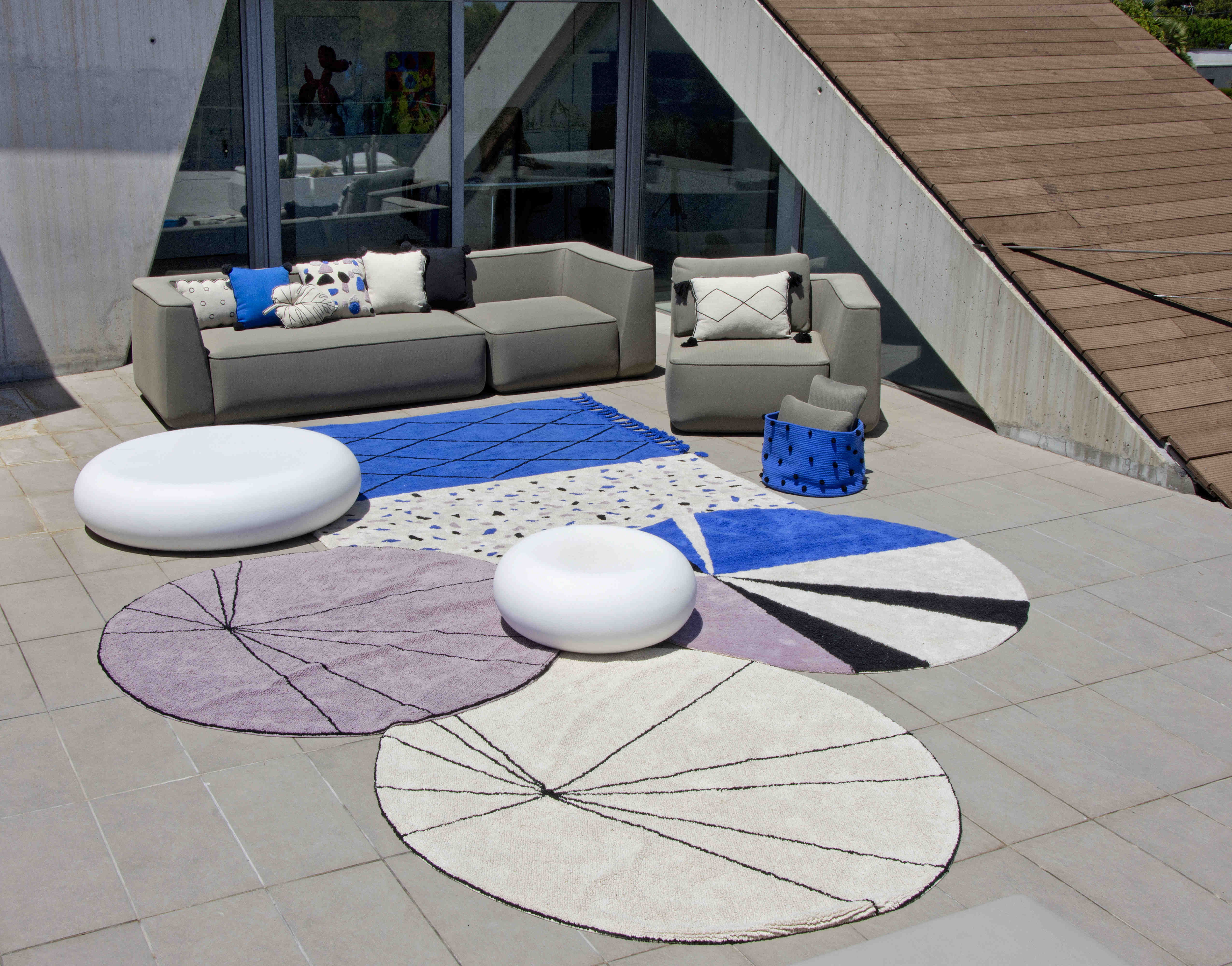 A circular shaped beige cotton rug decorated with geometric black lines