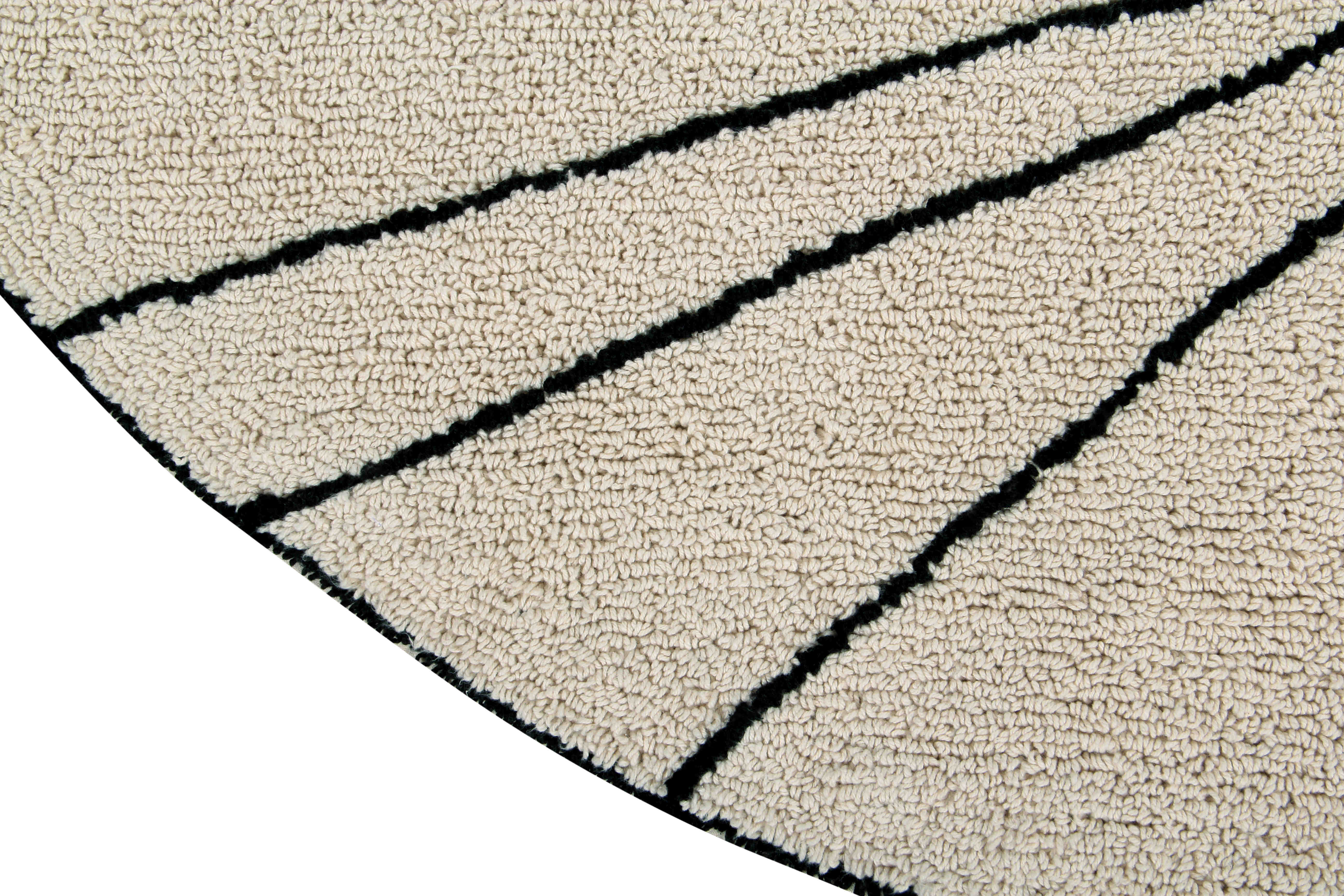 A circular shaped beige cotton rug decorated with geometric black lines