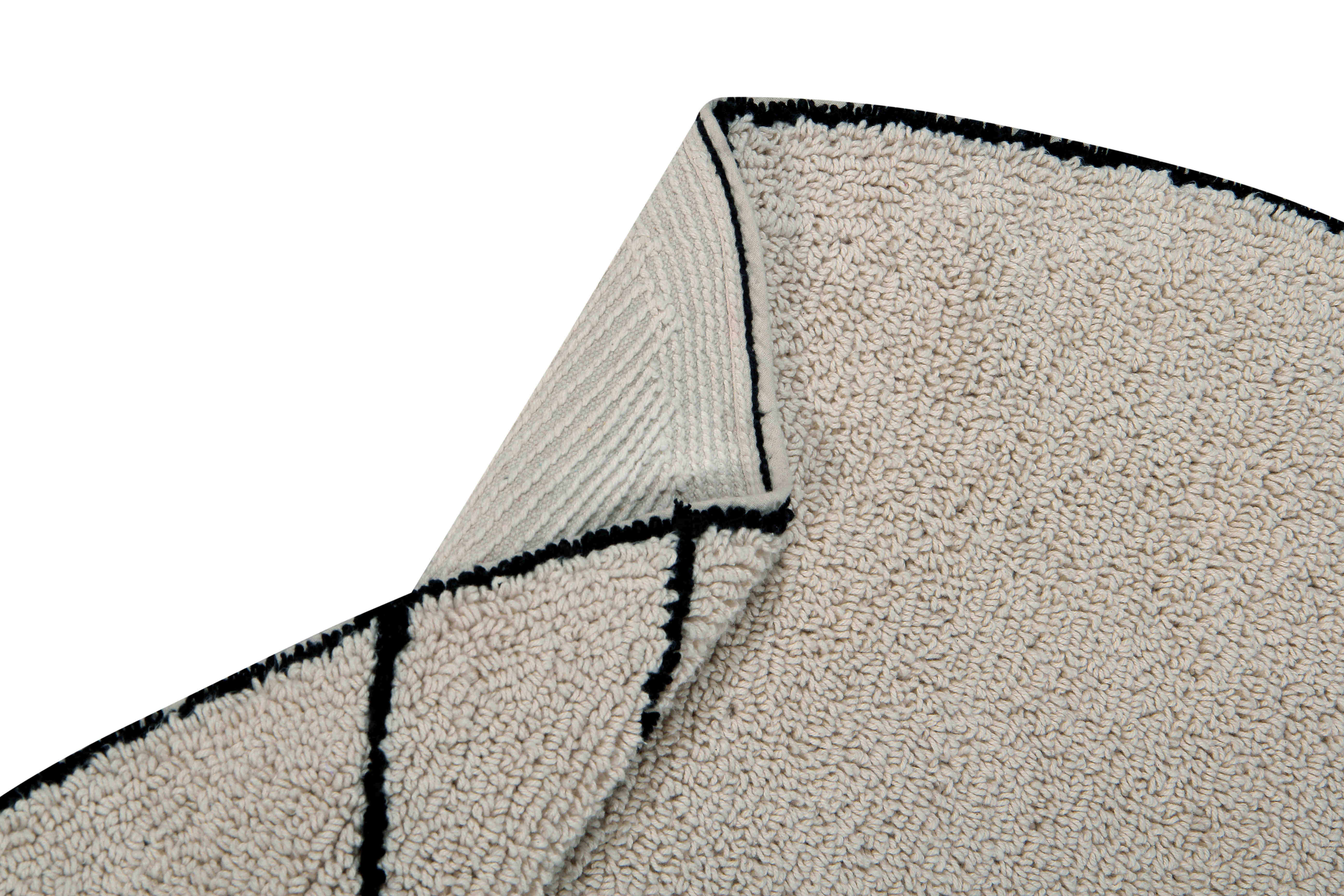 A circular shaped beige cotton rug decorated with geometric black lines