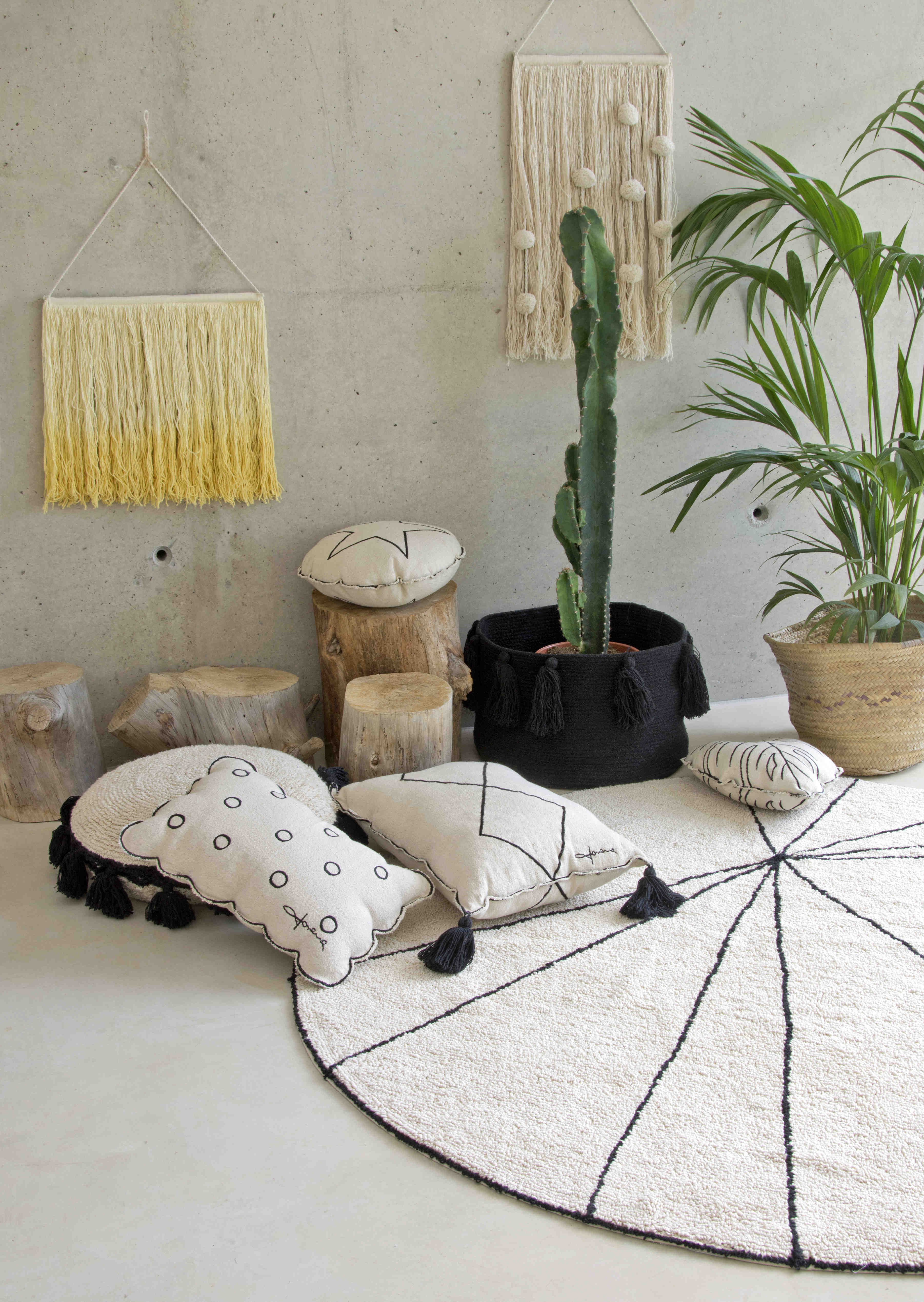 A circular shaped beige cotton rug decorated with geometric black lines