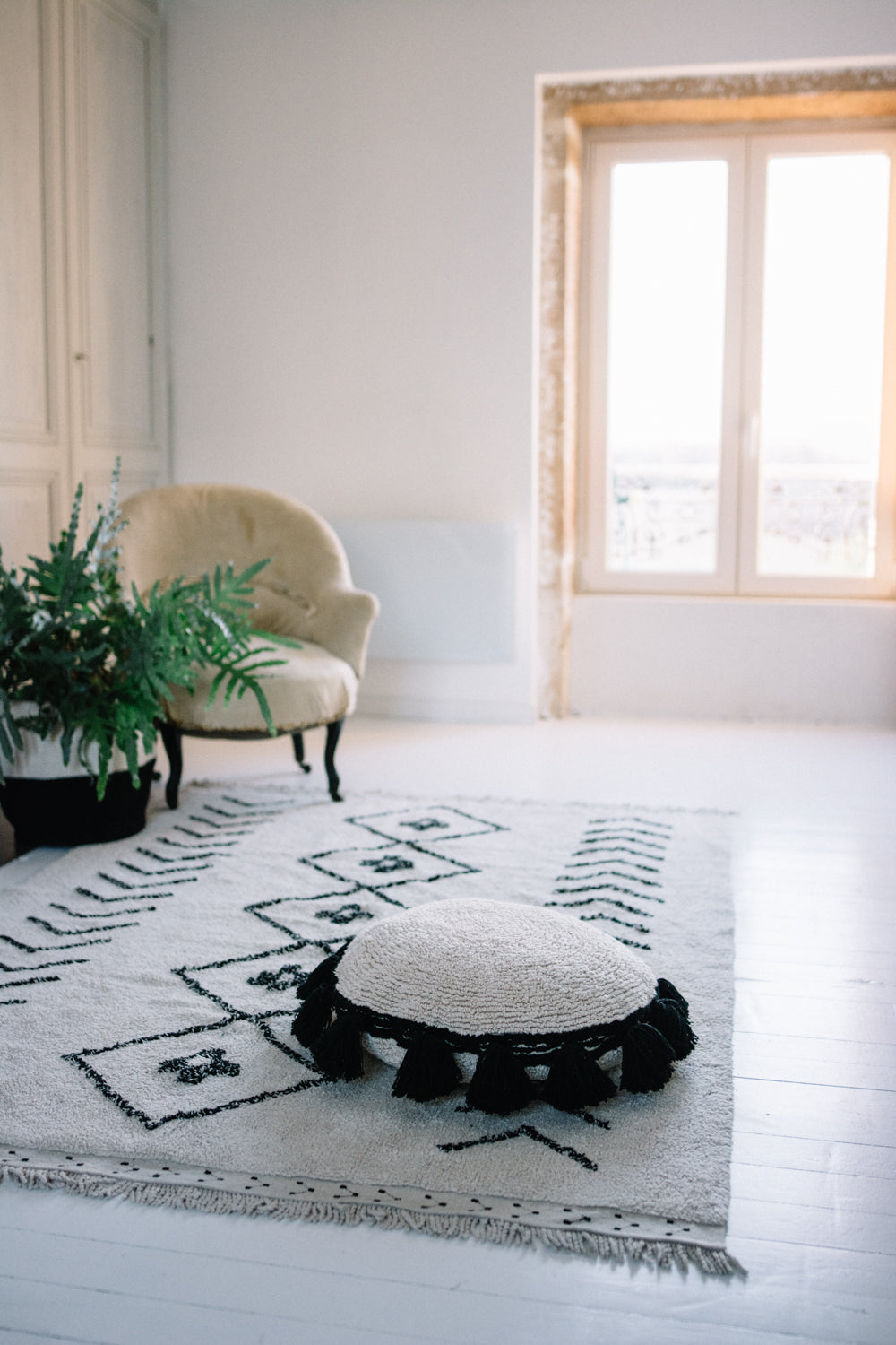 Rectangular beige cotton rug decorated with a black moroccan tribal designs