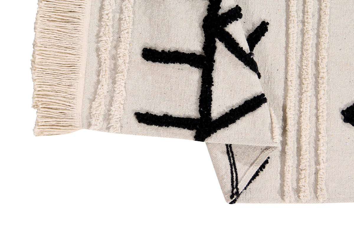 Rectangular beige cotton rug decorated with a black moroccan tribal design and a fringed border